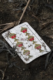 a broken playing card laying on the ground
