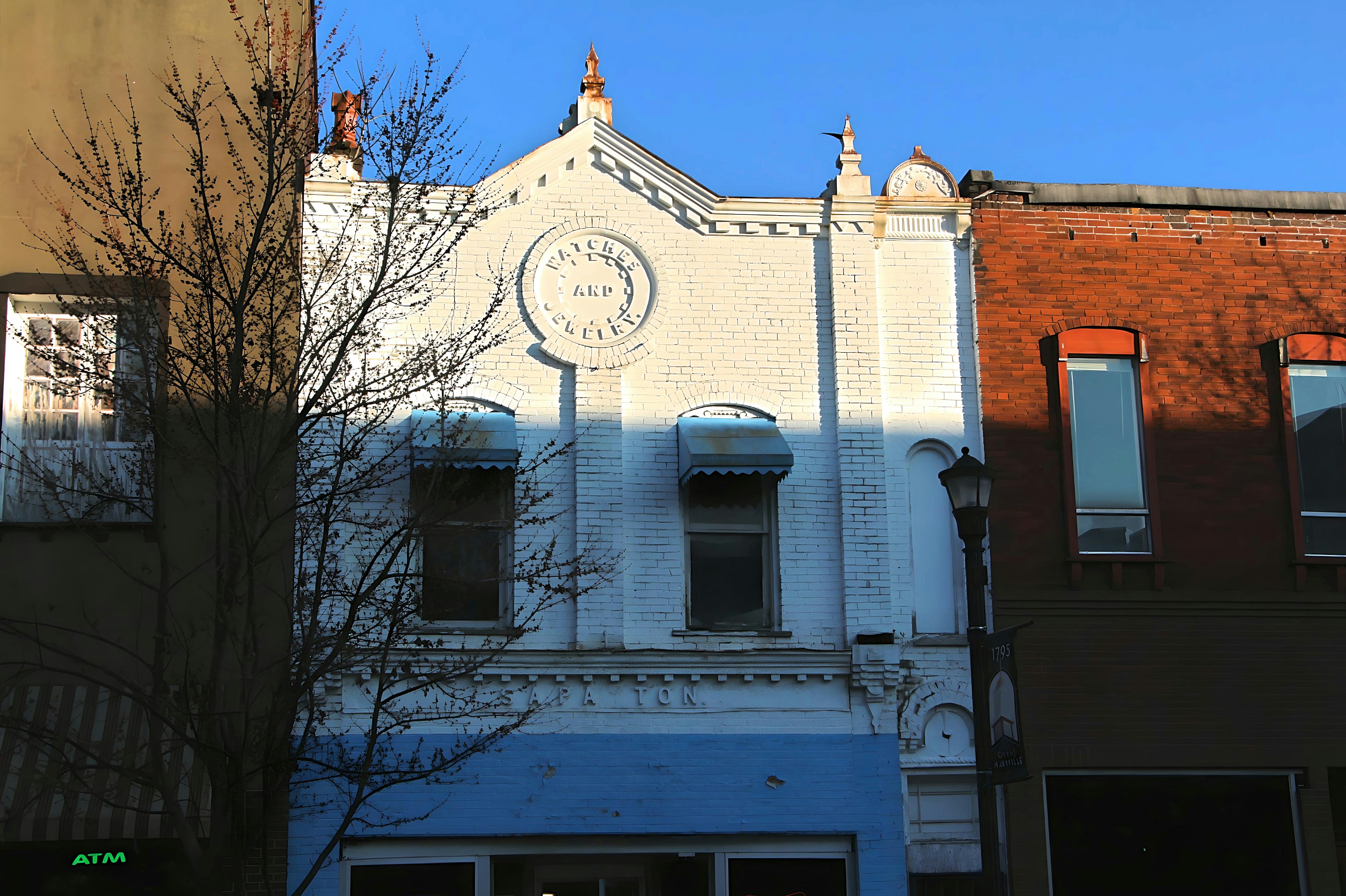 a tall white building with a clock on it's side
