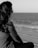 a woman sitting on the beach looking out at the ocean