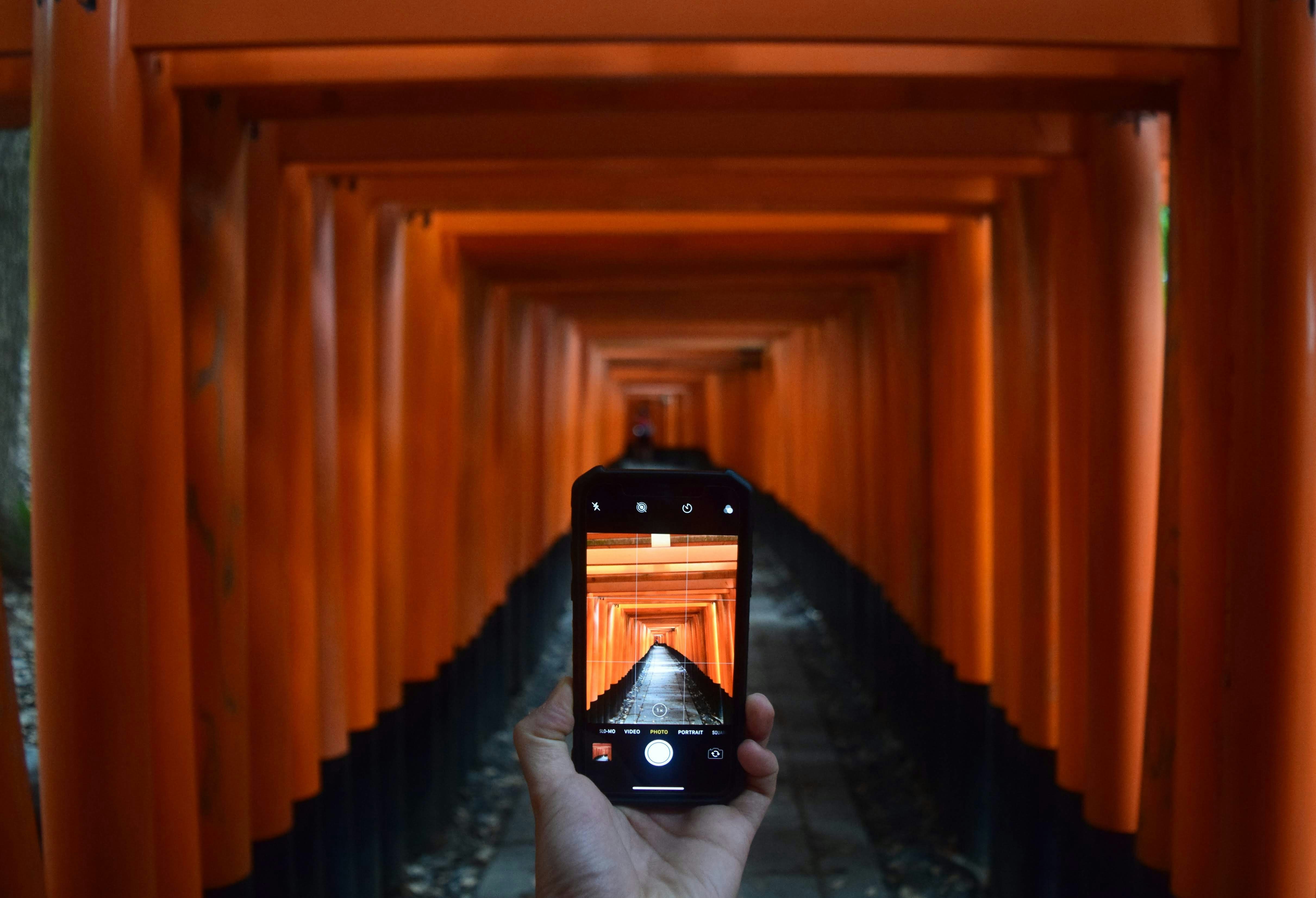 オレンジ色のトンネルの写真を撮る人