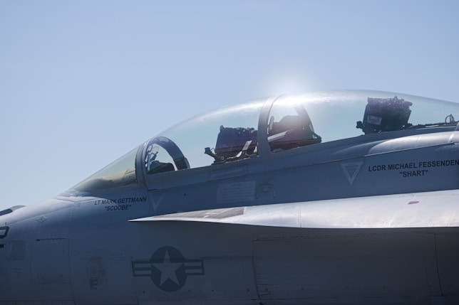 a fighter jet sitting on top of an airport tarmac