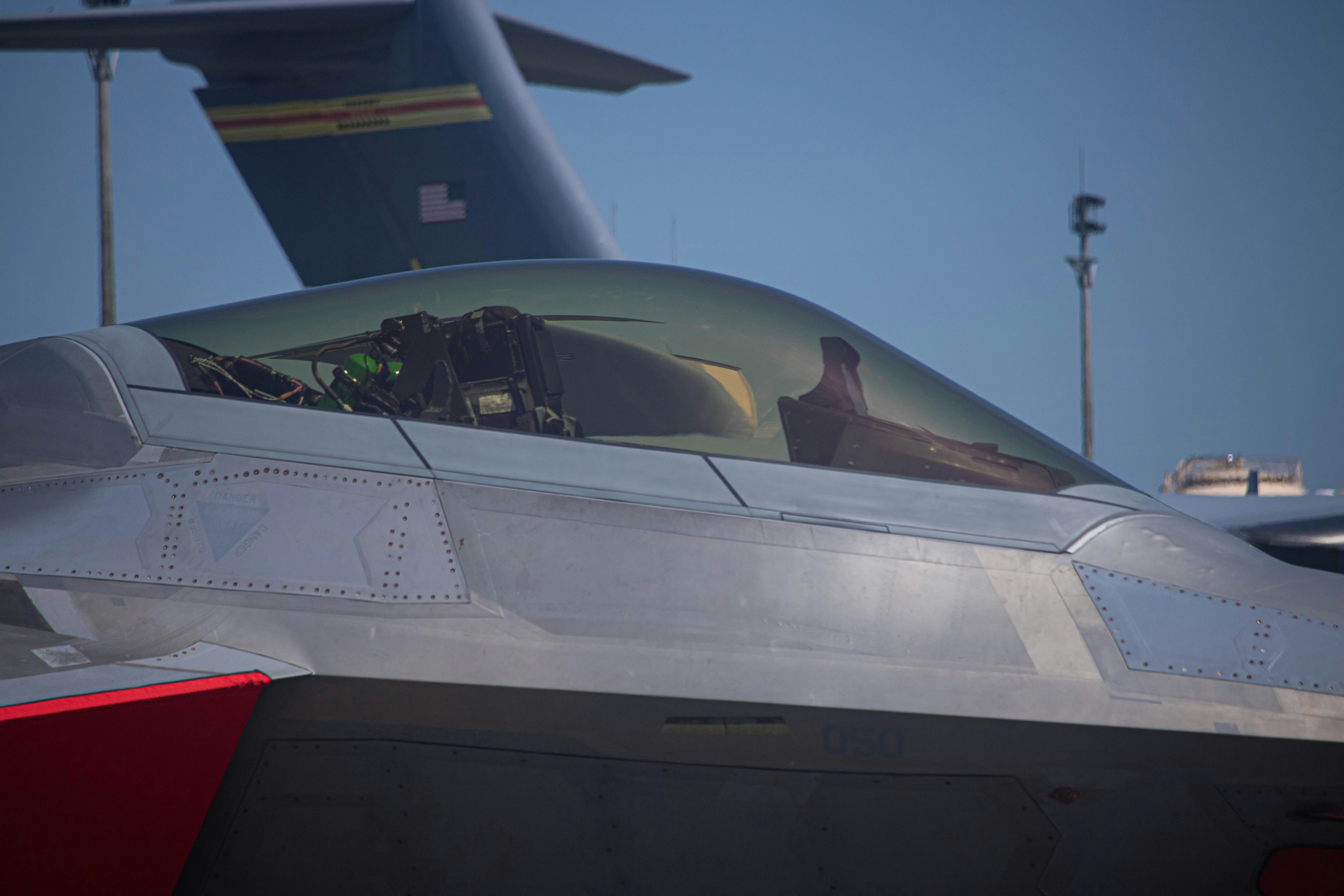 a fighter jet sitting on top of an airport tarmac, 