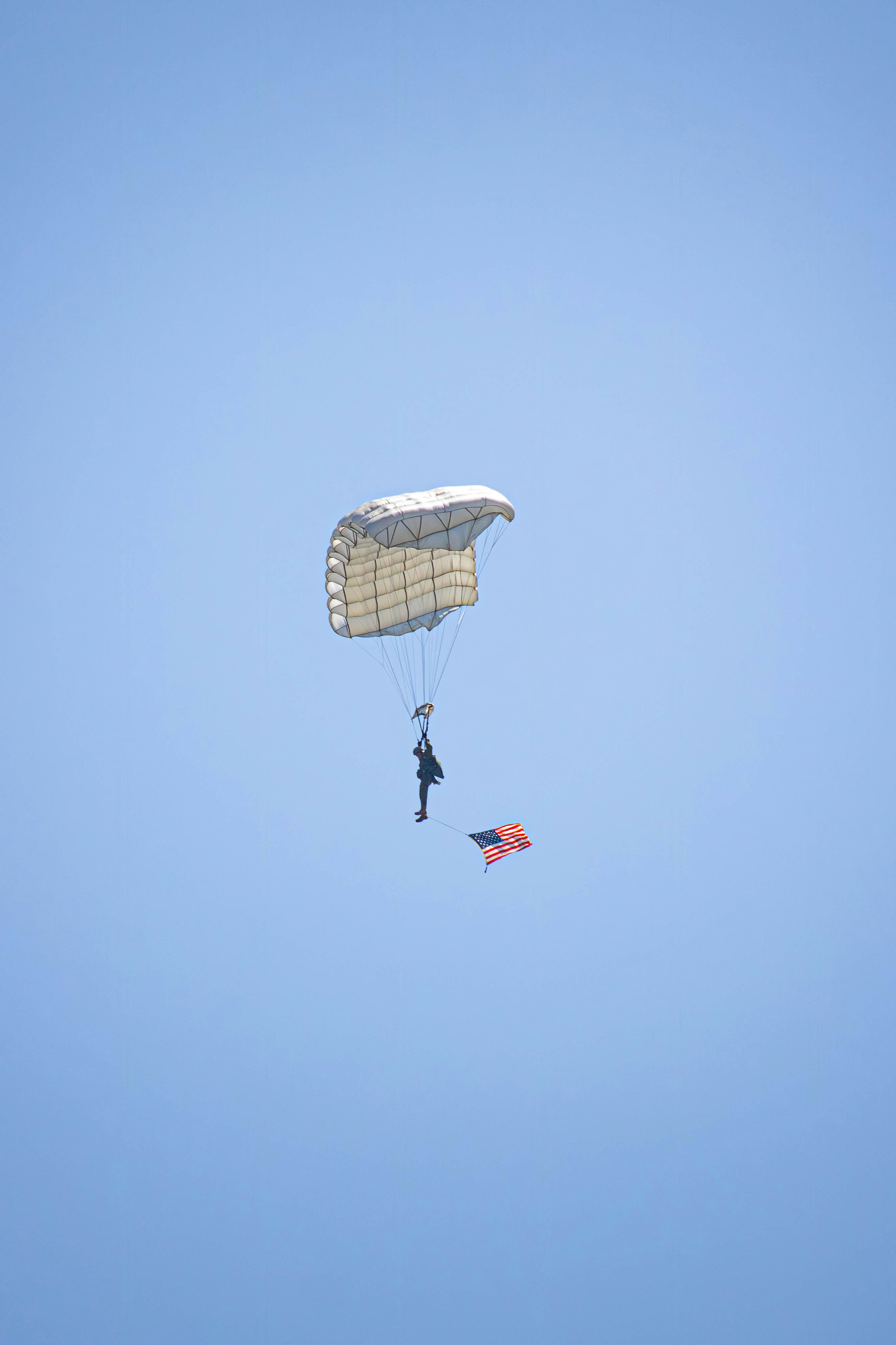 a person is parasailing in the blue sky