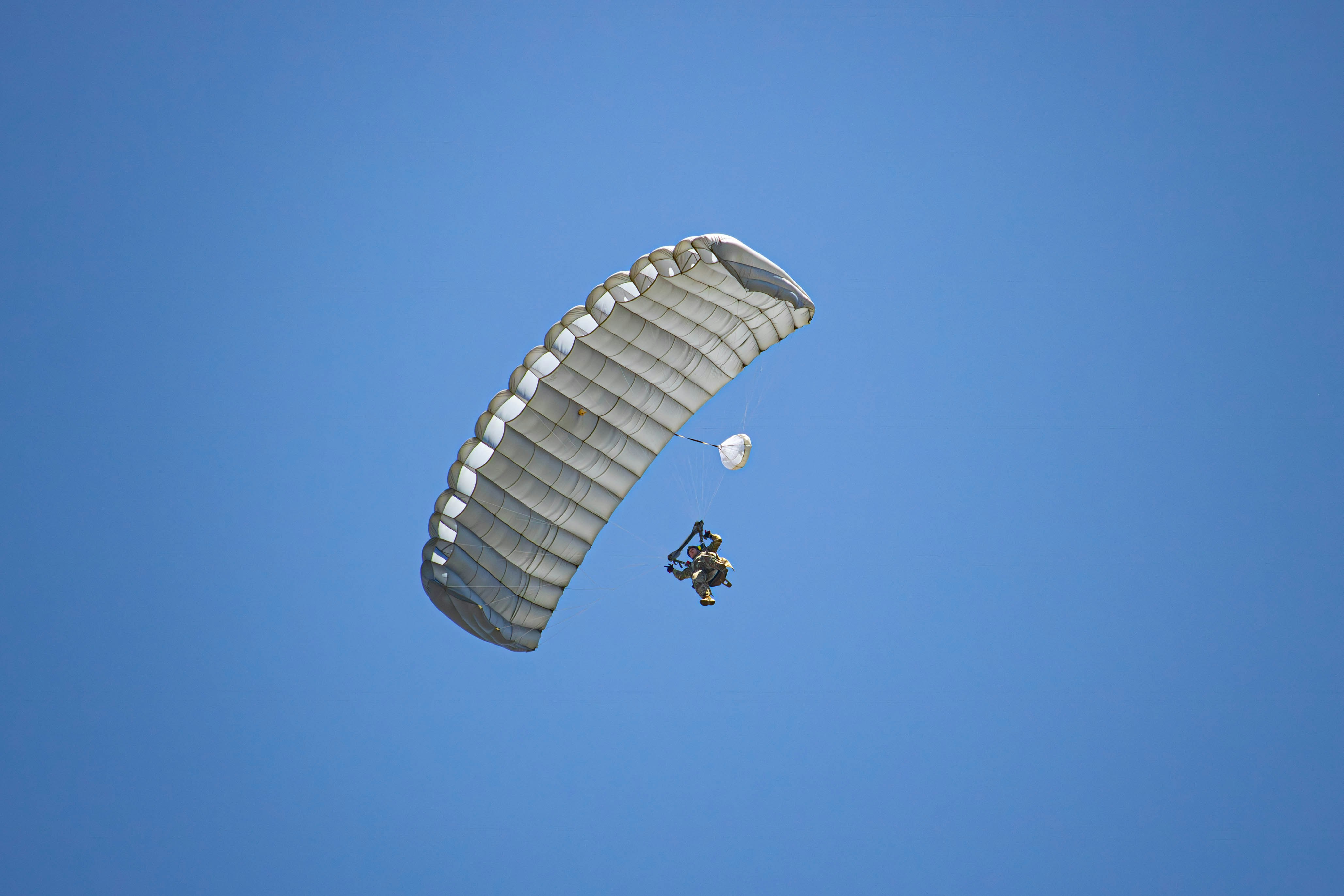 a person is parasailing in the blue sky