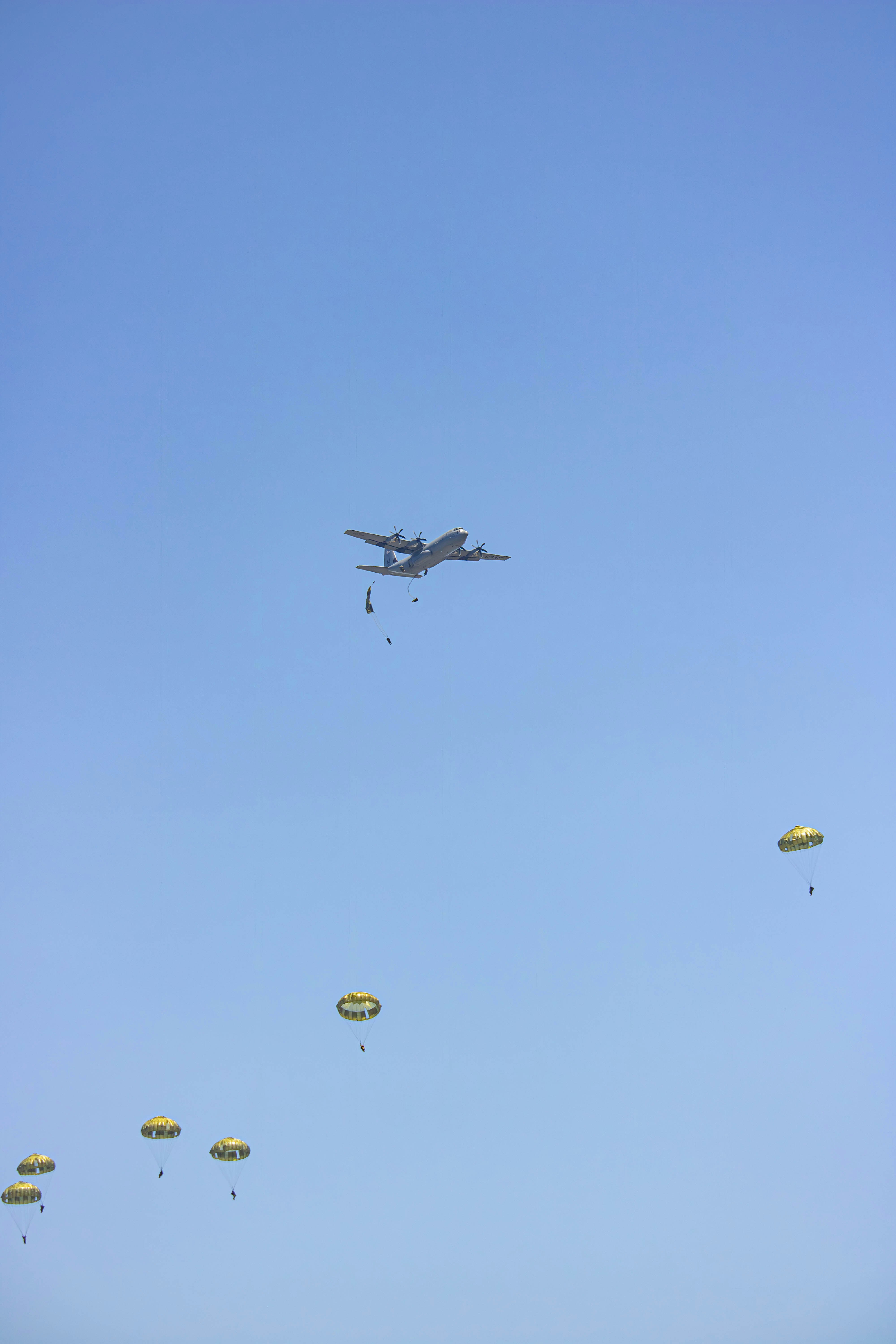 a large air plane flying through a blue sky