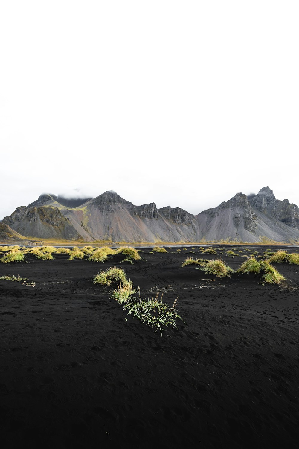 a black landscape with mountains in the background