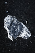 a piece of ice sitting on top of a black surface
