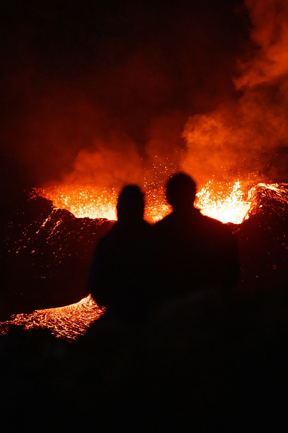 a couple of people standing in front of a fire