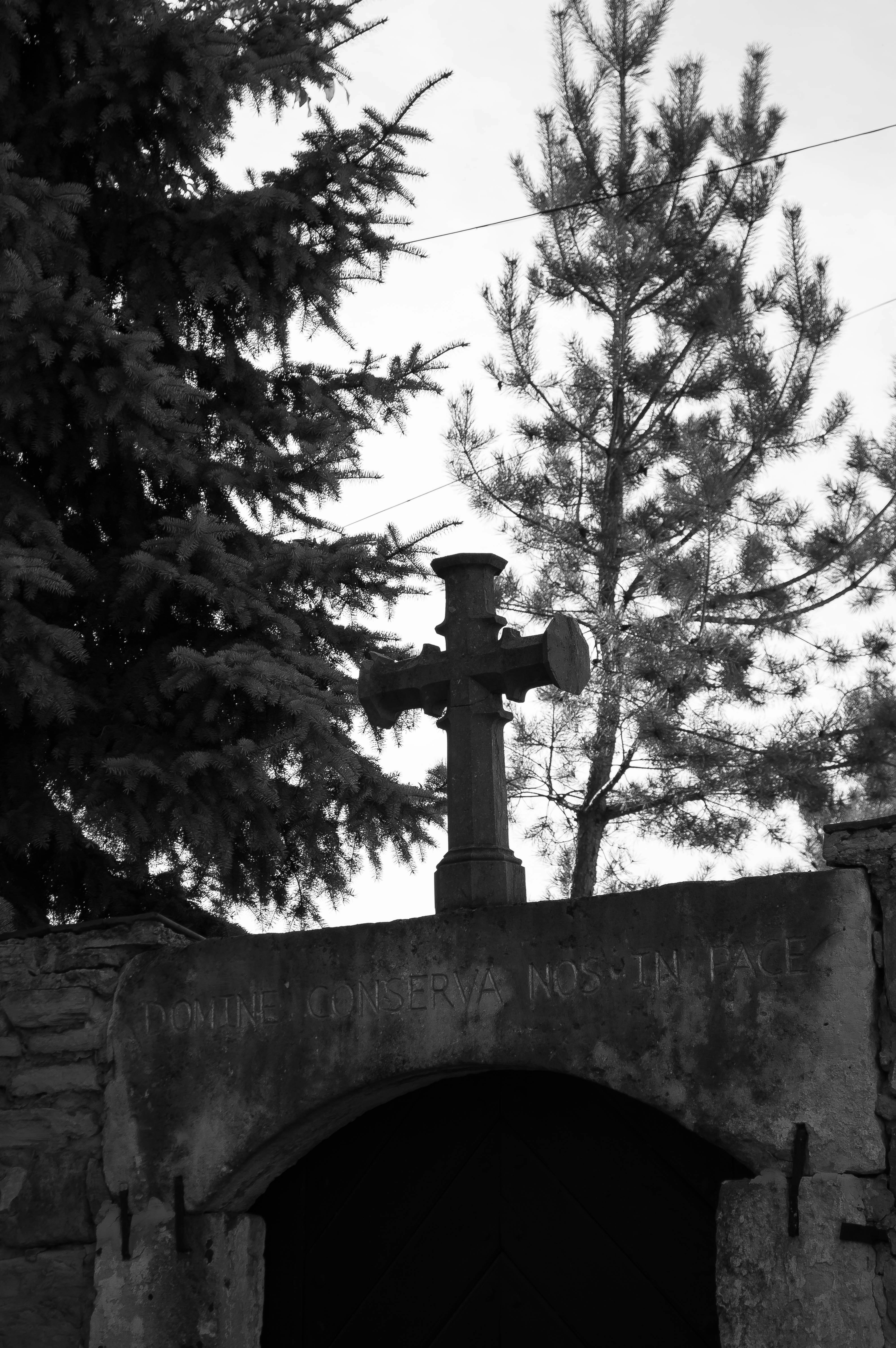 a black and white photo of a cross on top of a building