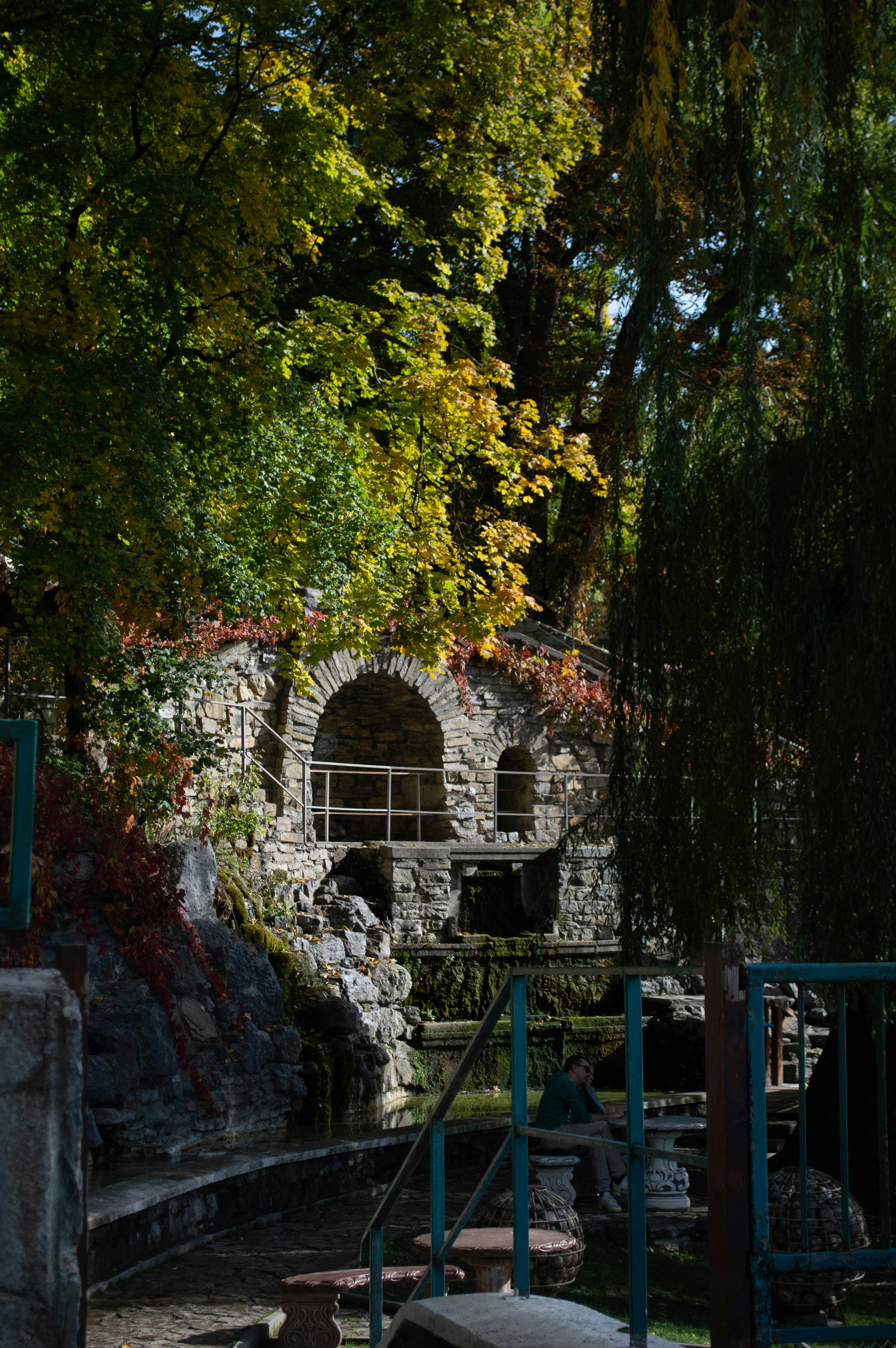 a stone building sitting next to a forest filled with trees