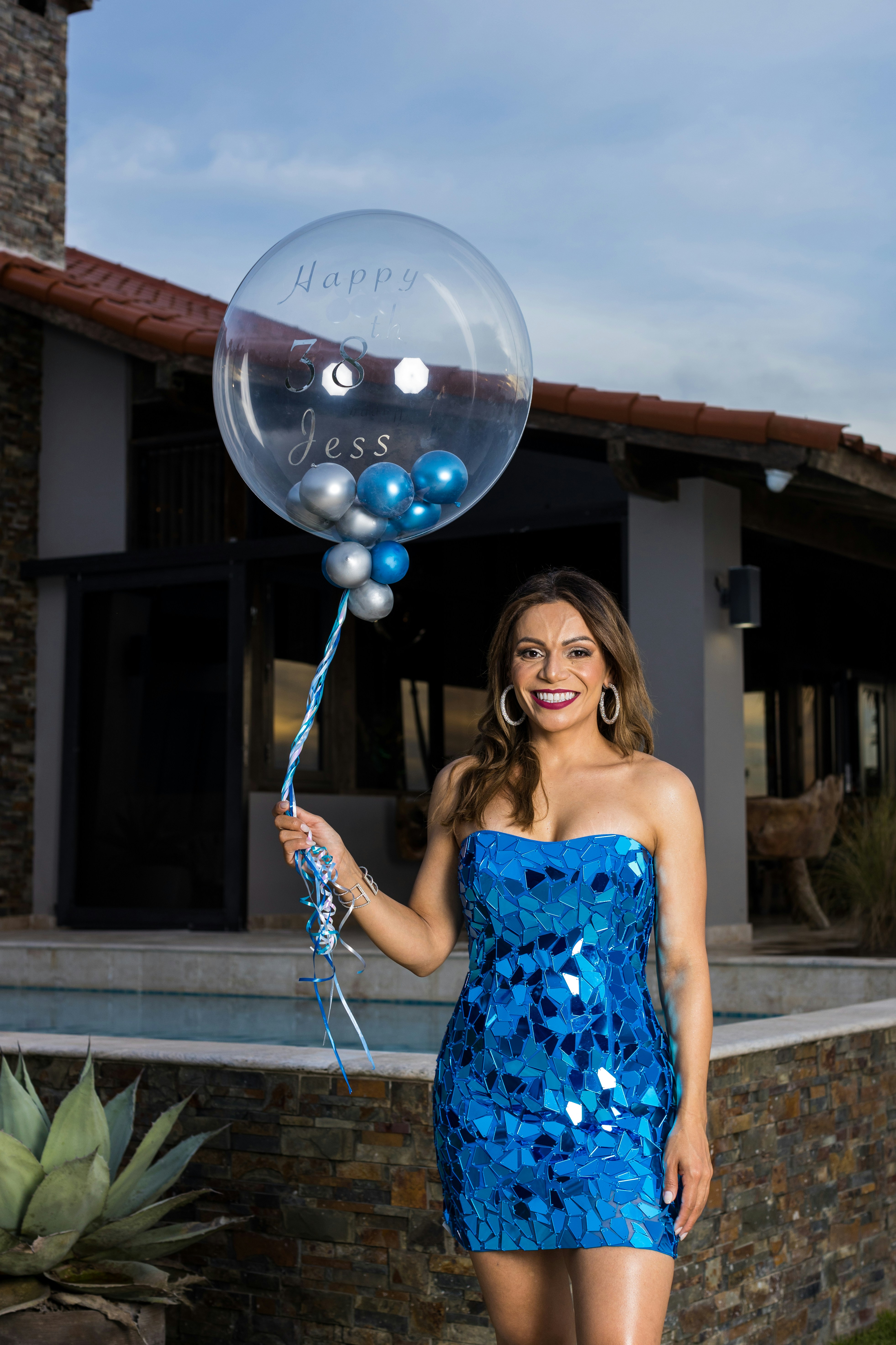 a woman in a blue dress holding a bubble balloon