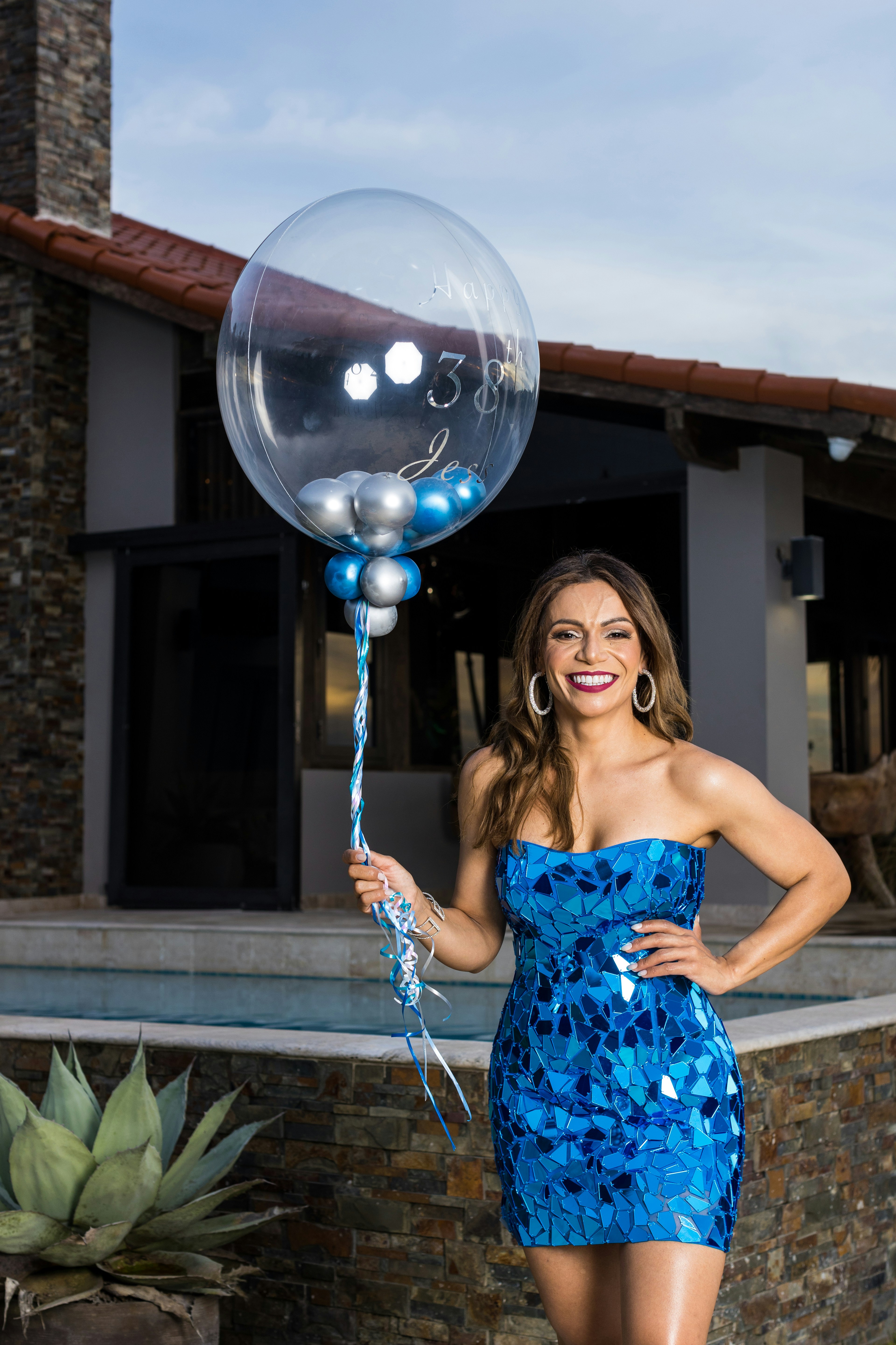 a woman in a blue dress holding a balloon