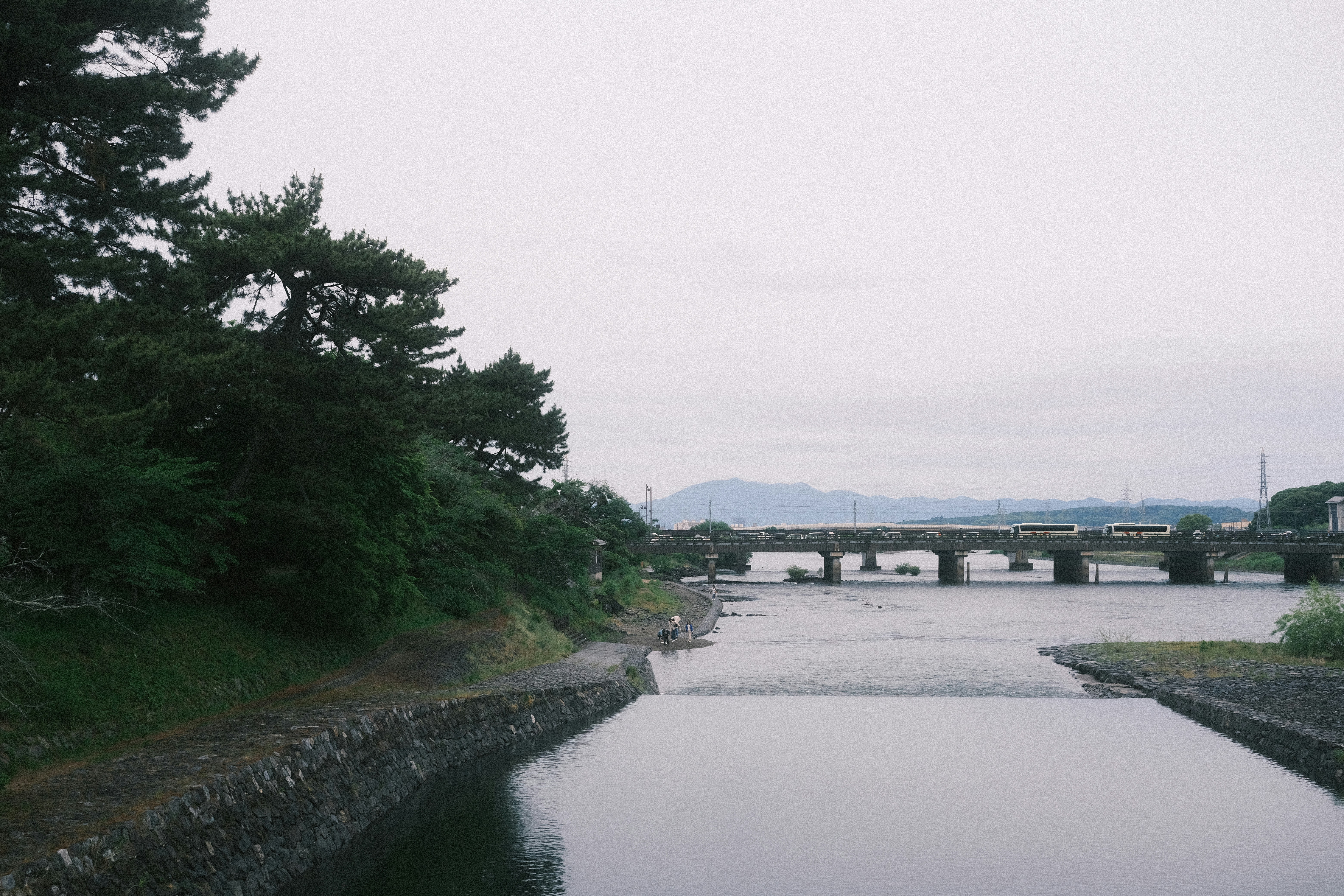 a body of water with a bridge in the background