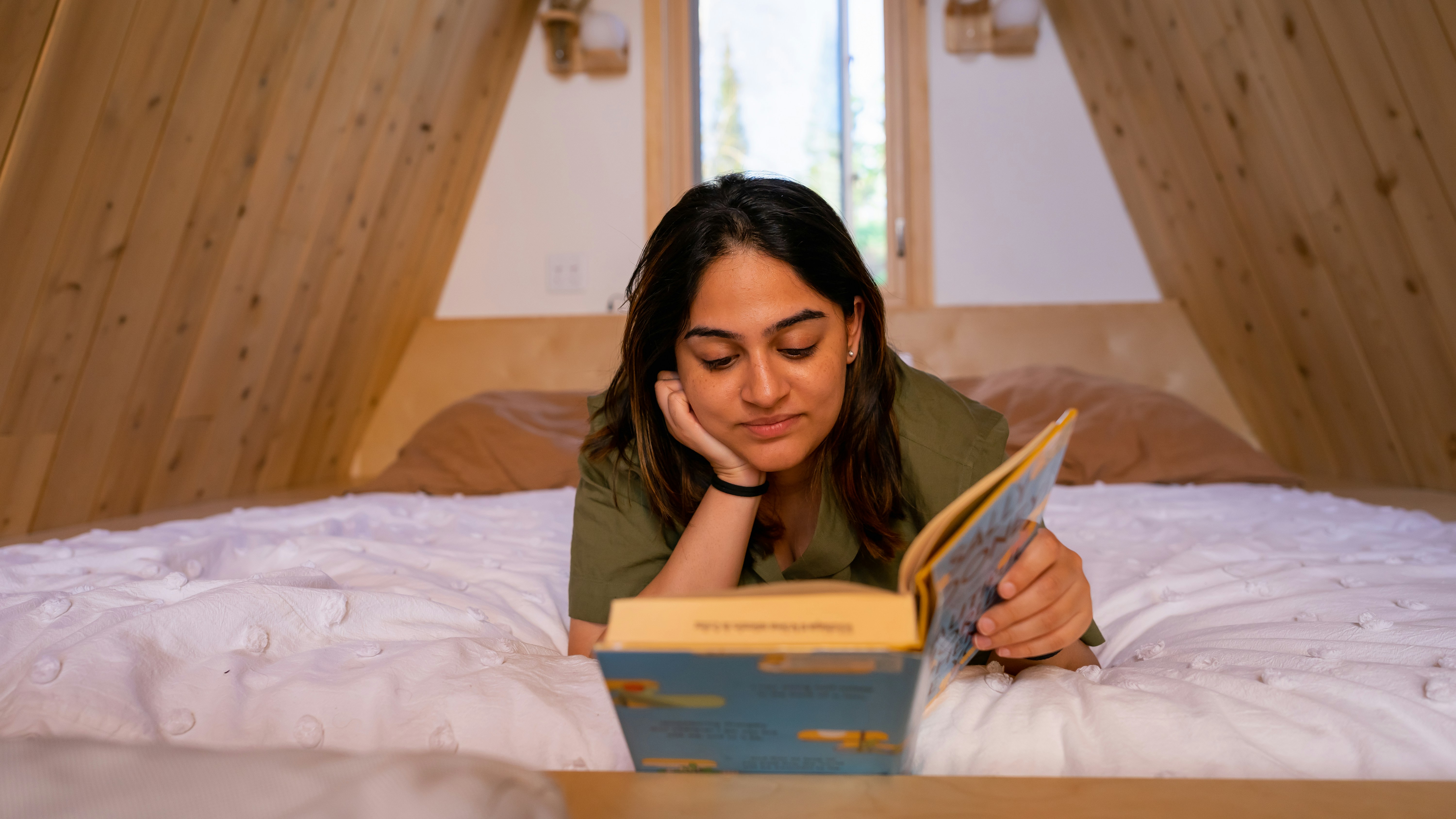 Eine Frau, die auf einem Bett liegt und ein Buch liest
