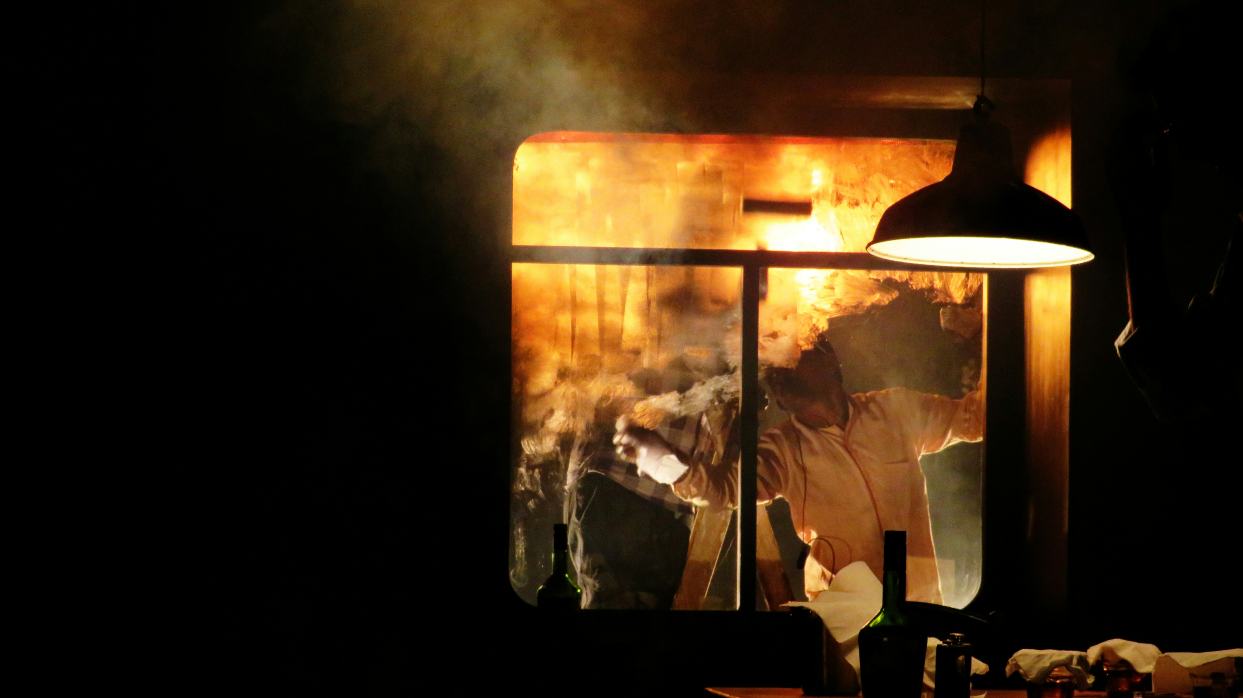 a person standing in front of a window with smoke coming out of it