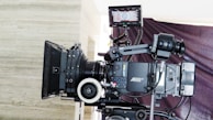 a camera set up on a tripod in front of a wall