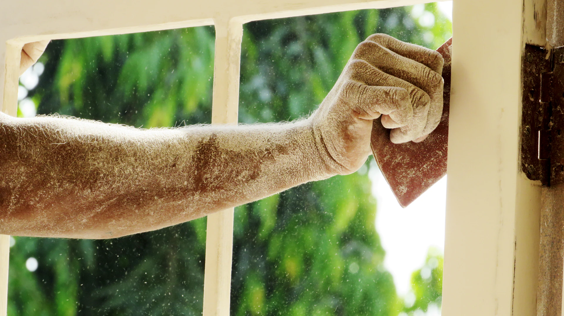 a man's arm is covered in dirt as he opens a window