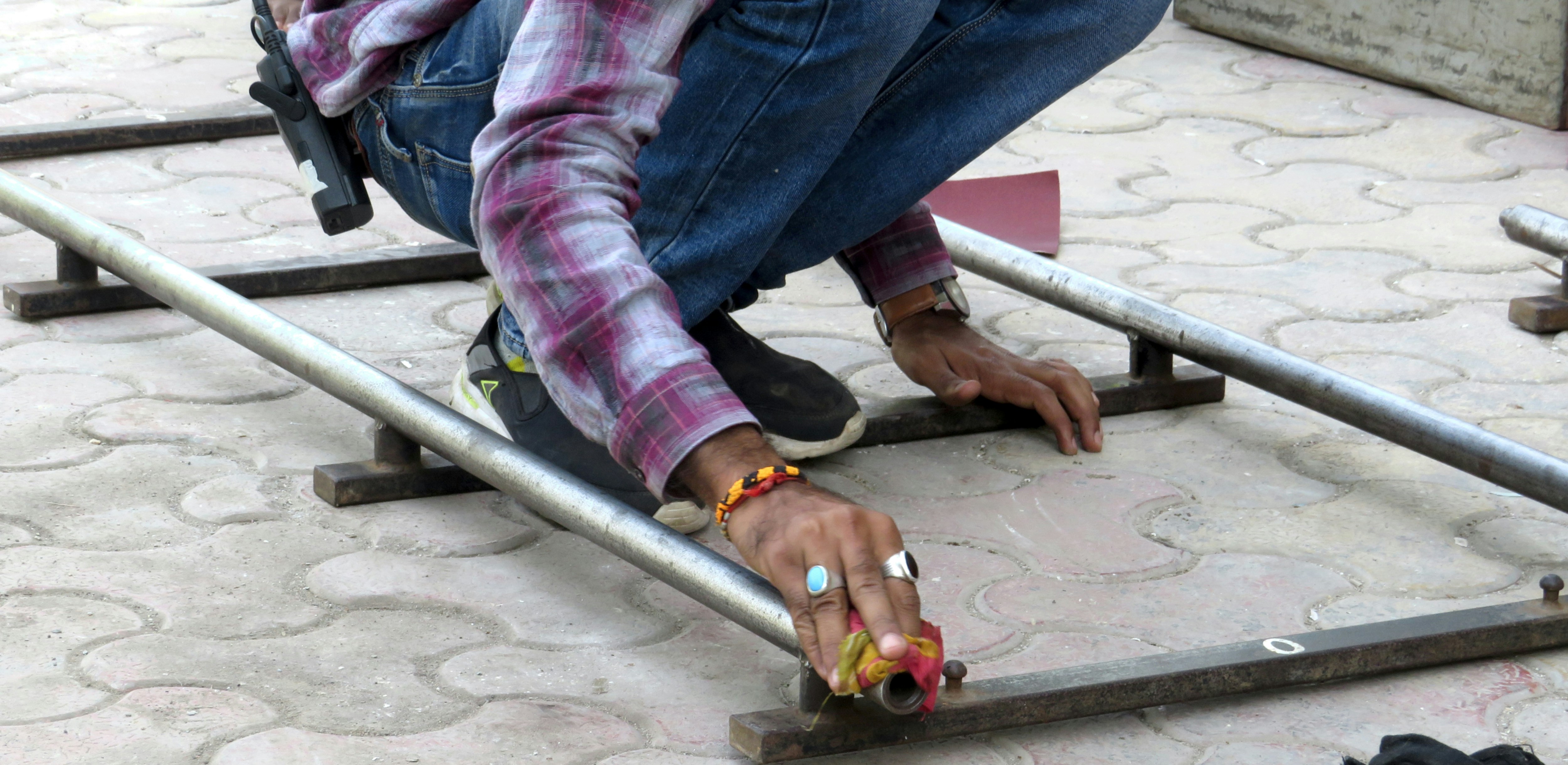 a man kneeling down on a metal rail