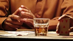 a man sitting at a table with a glass of whiskey