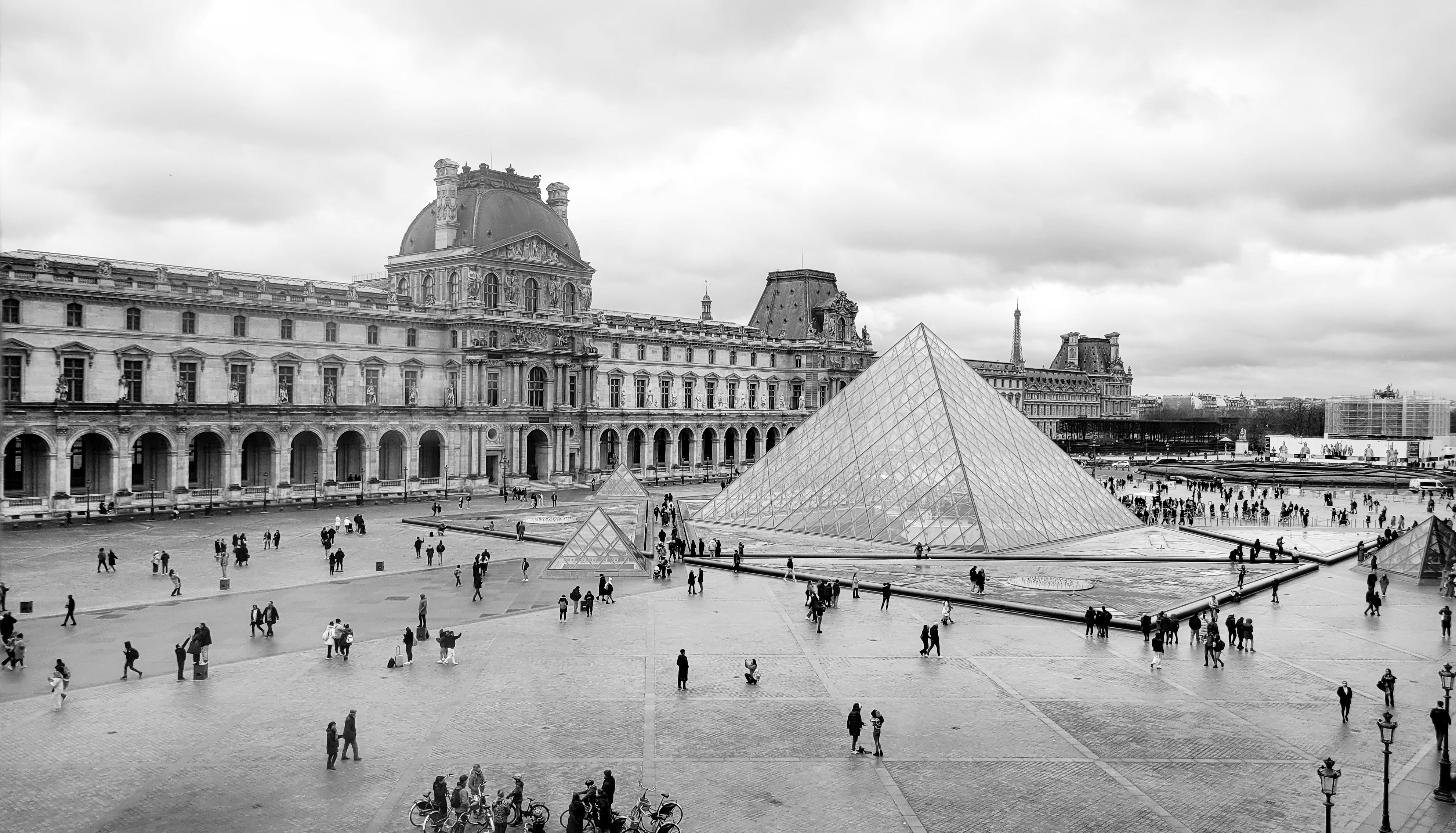 a black and white photo of a pyramid in a courtyard