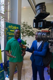 a man in a green shirt talking to a man in a blue suit