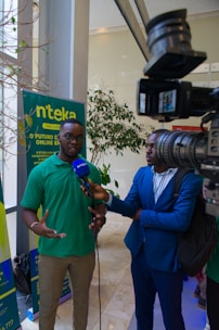 a man in a green shirt talking to a man in a blue suit