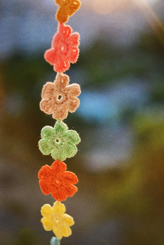 a string of crocheted flowers hanging from a string