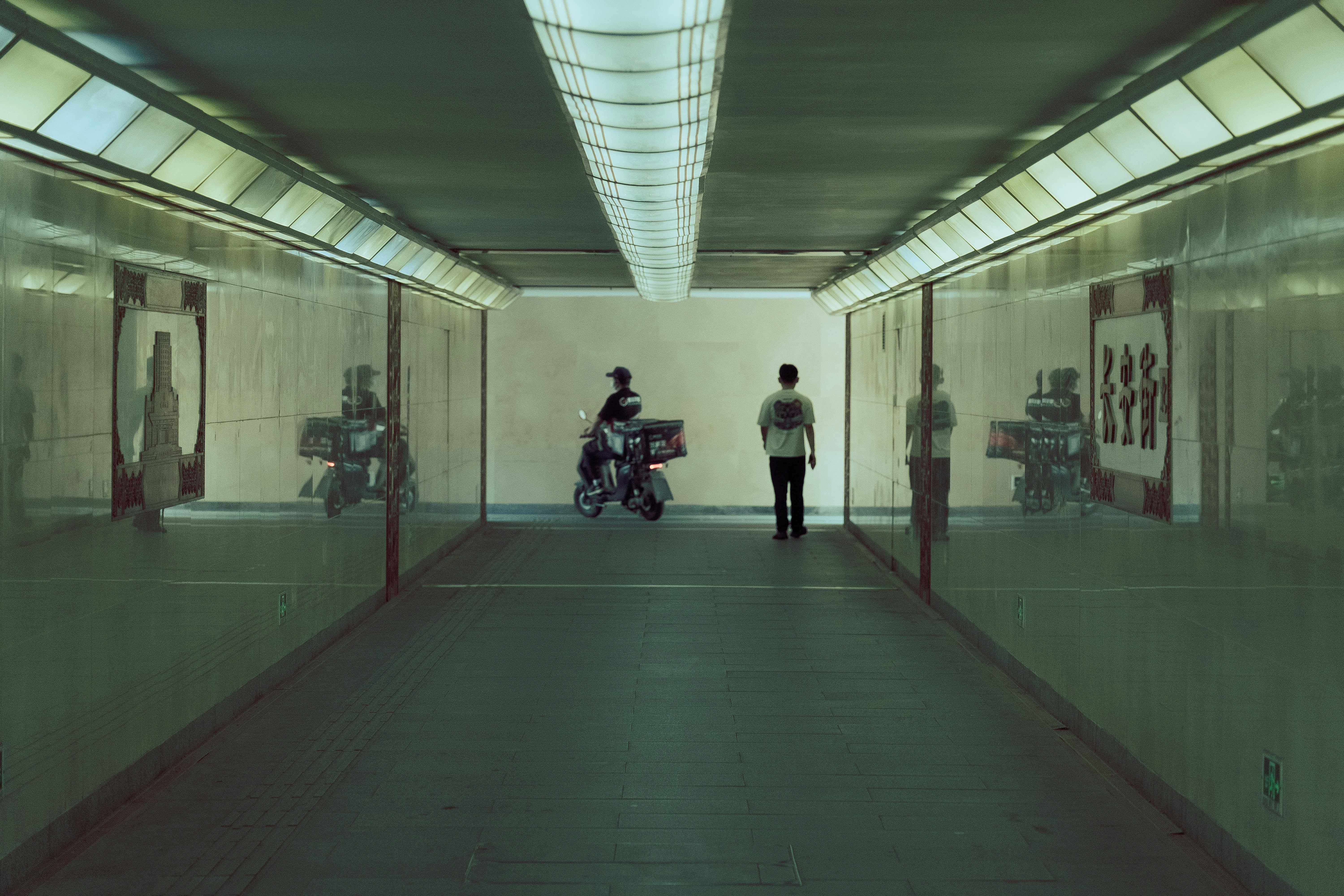 a man standing in a hallway next to a motorcycle