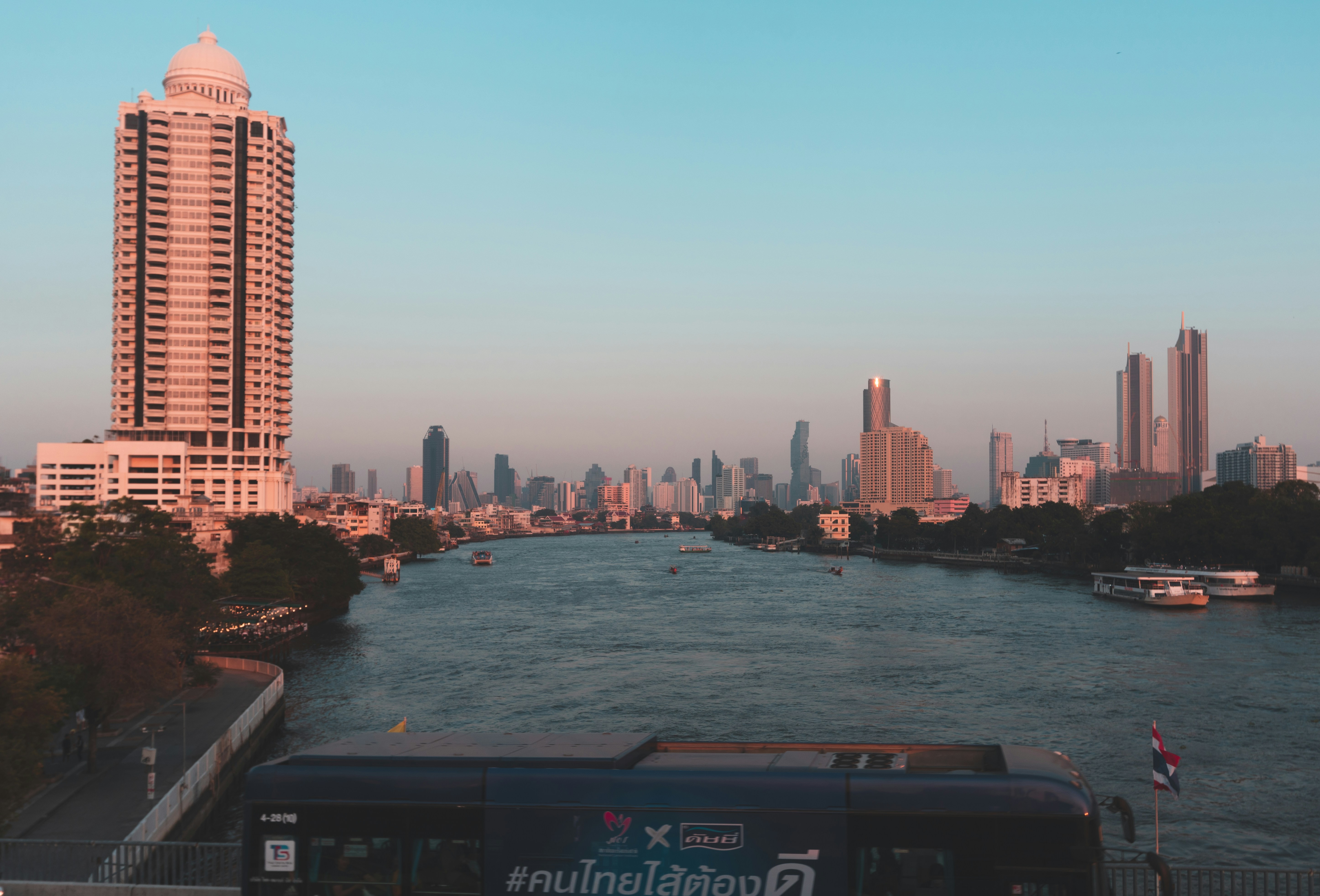 a bus driving down a street next to a river