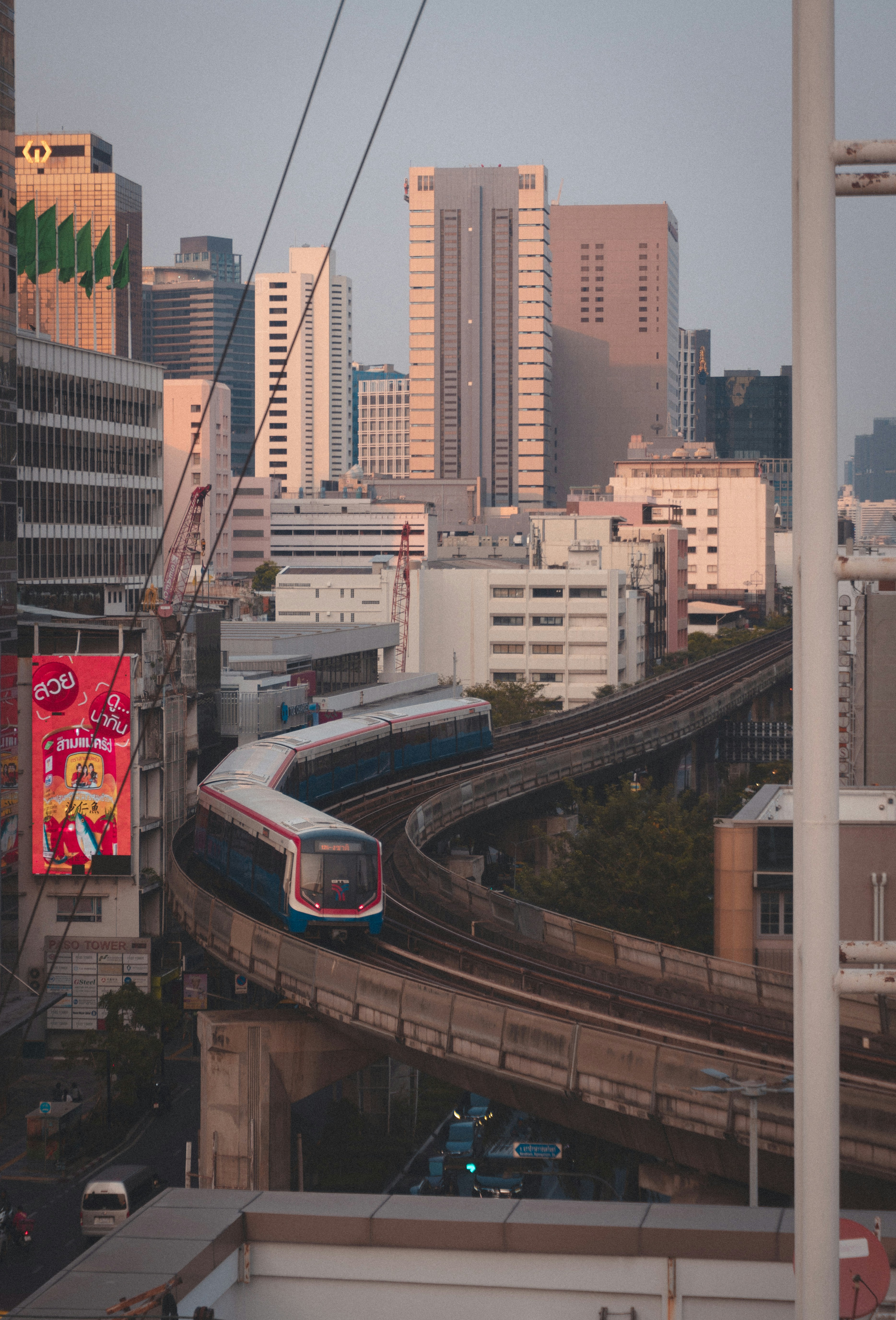 A train traveling through a city next to tall buildings photo – Free ...