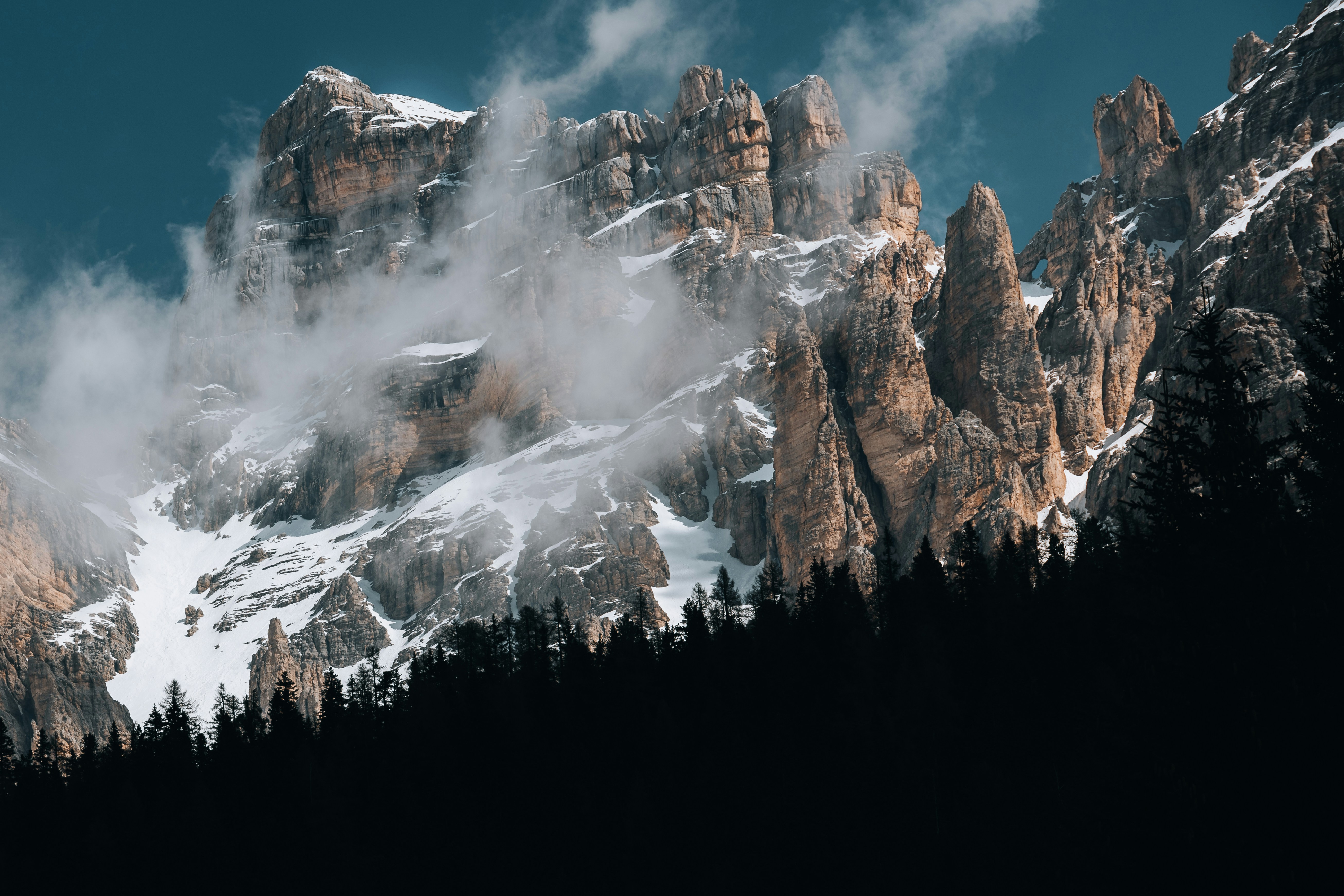 a mountain covered in snow surrounded by trees