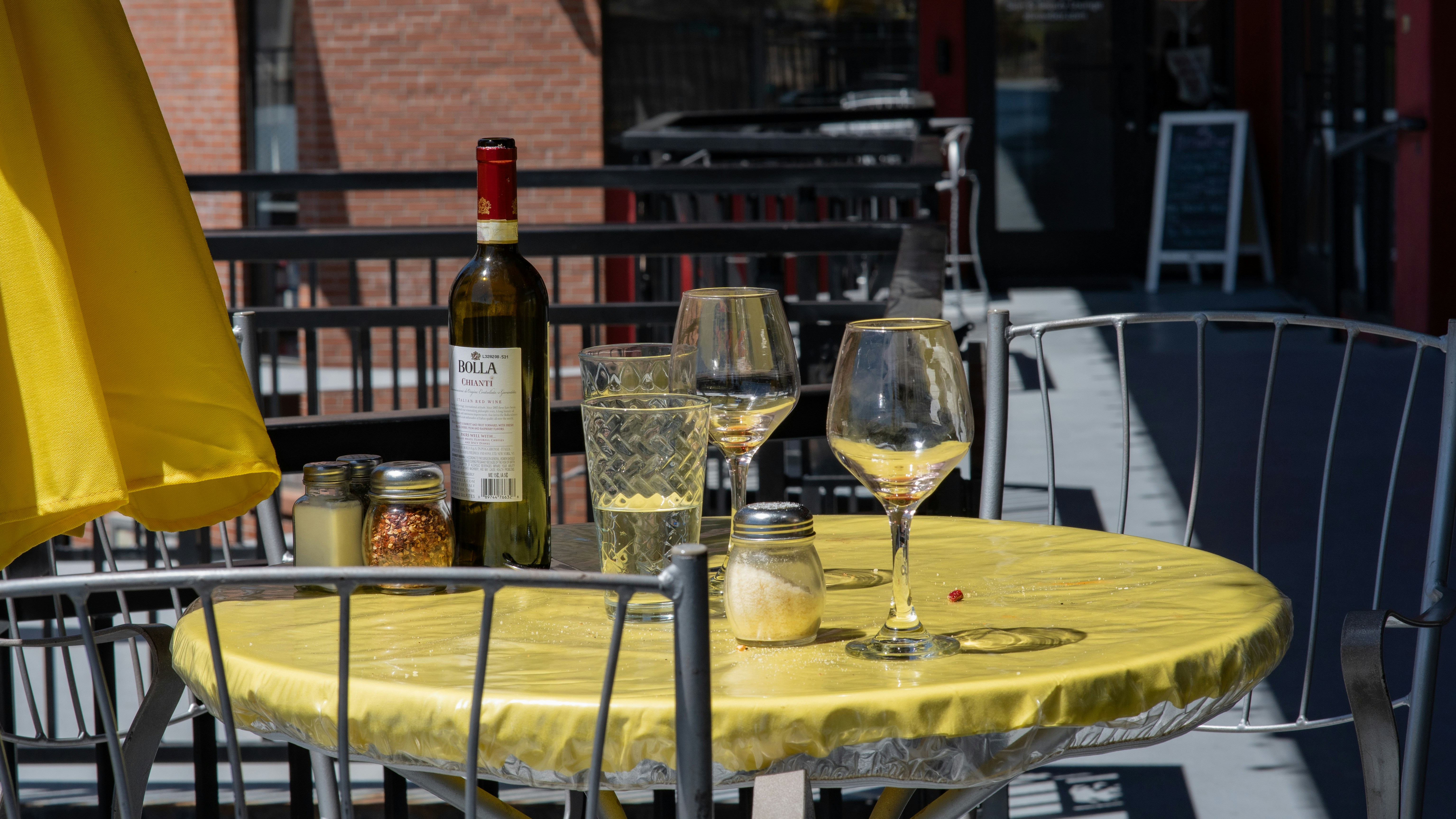 a table with two wine glasses and a bottle of wine on it, A couple had been dining here in the afternoon of one of my photoshoots. When the left, I stepped forward and capture their table as they left it.