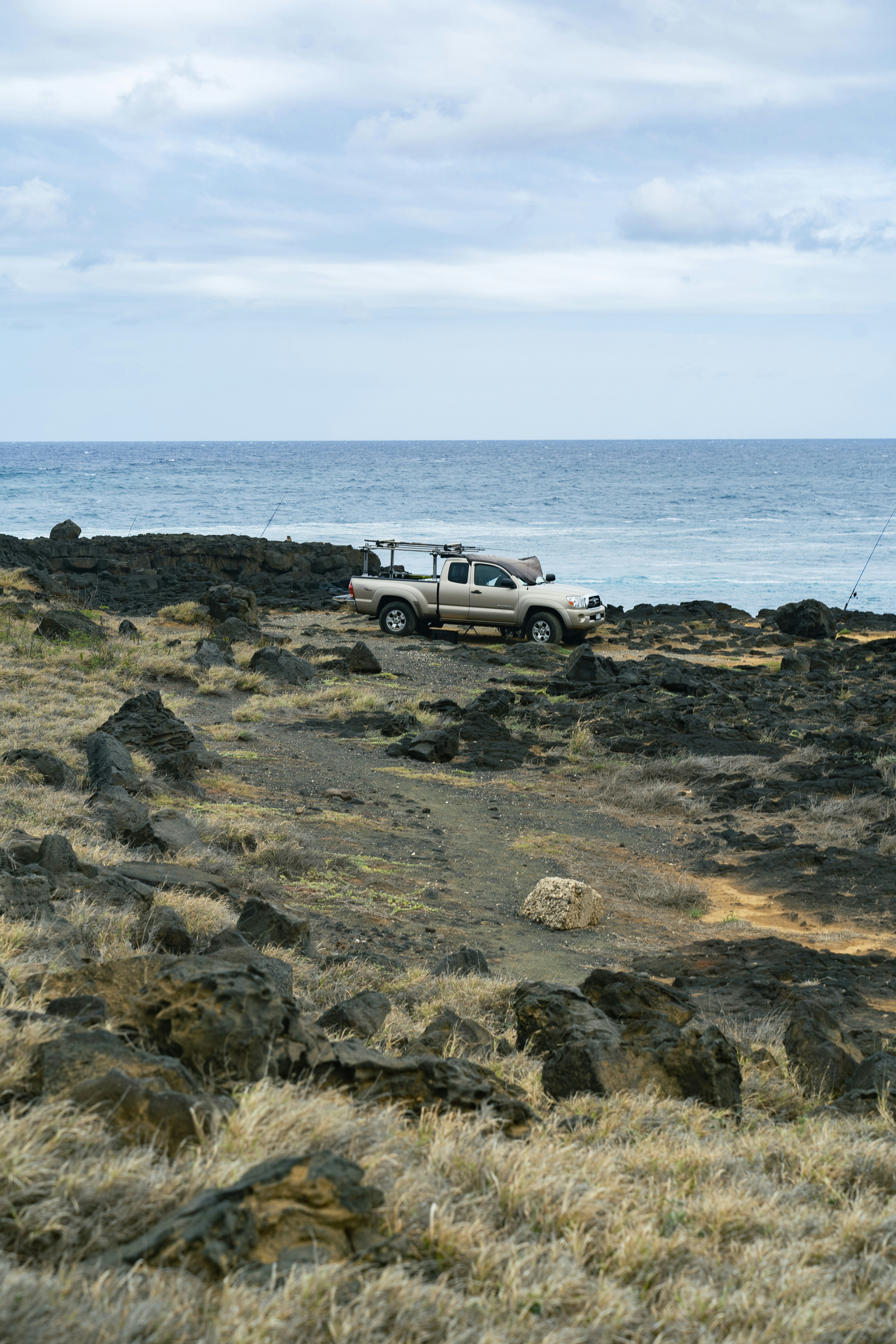 a truck parked on a rocky beach near the ocean