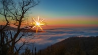 the sun is shining above the clouds in the sky