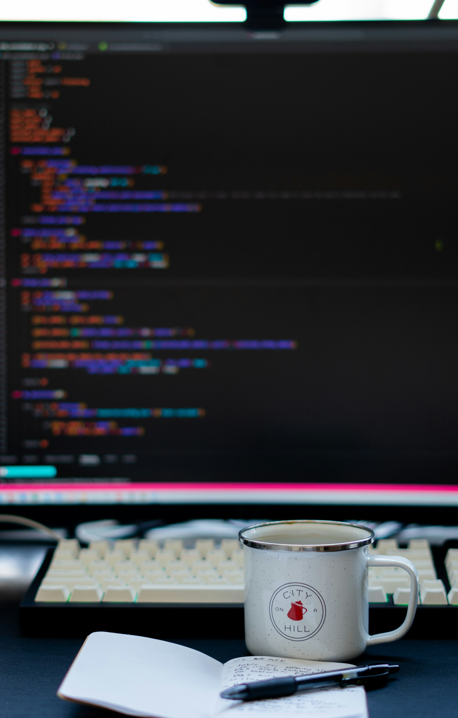 a cup of coffee sitting in front of a computer monitor