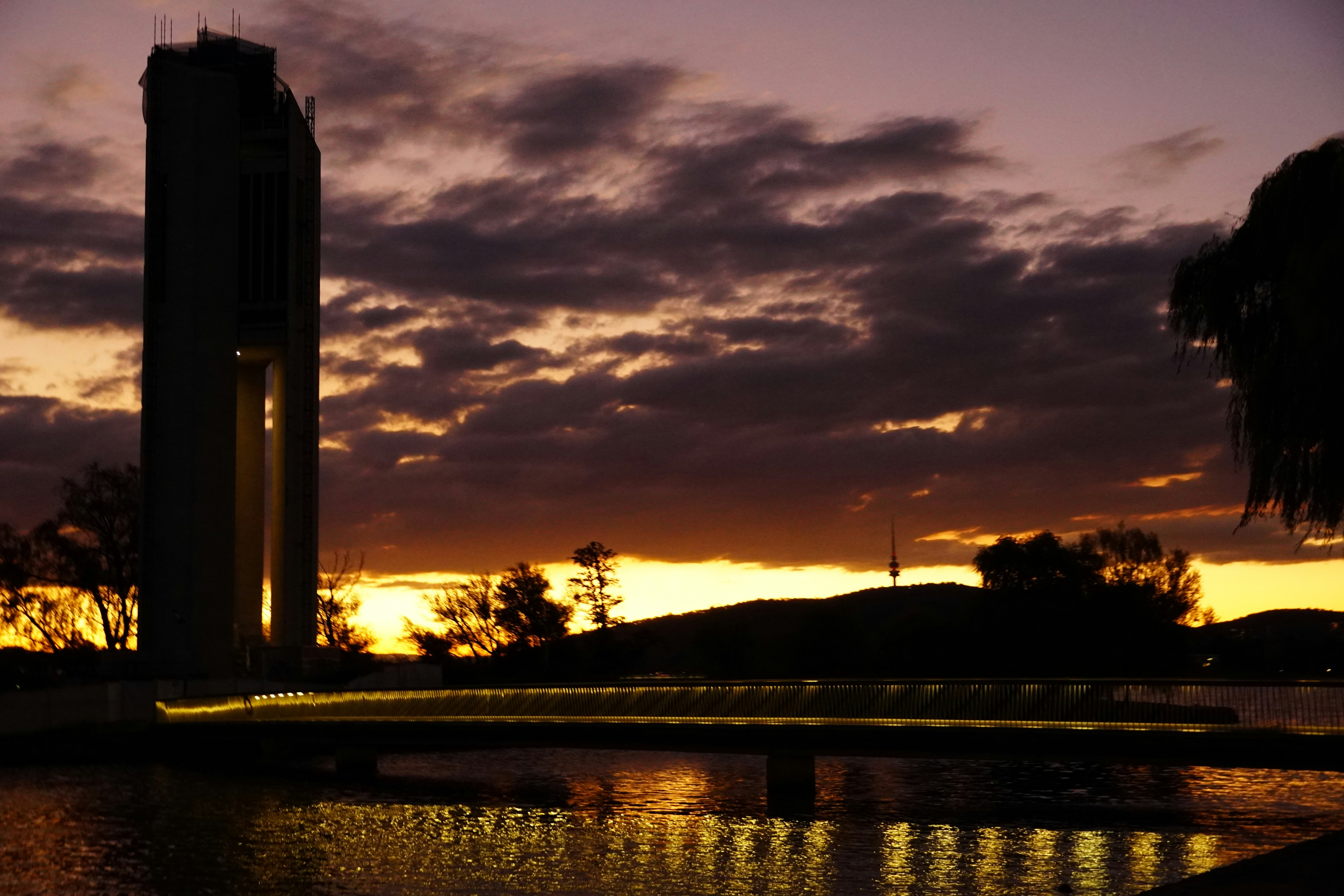 a clock tower is silhouetted against a sunset