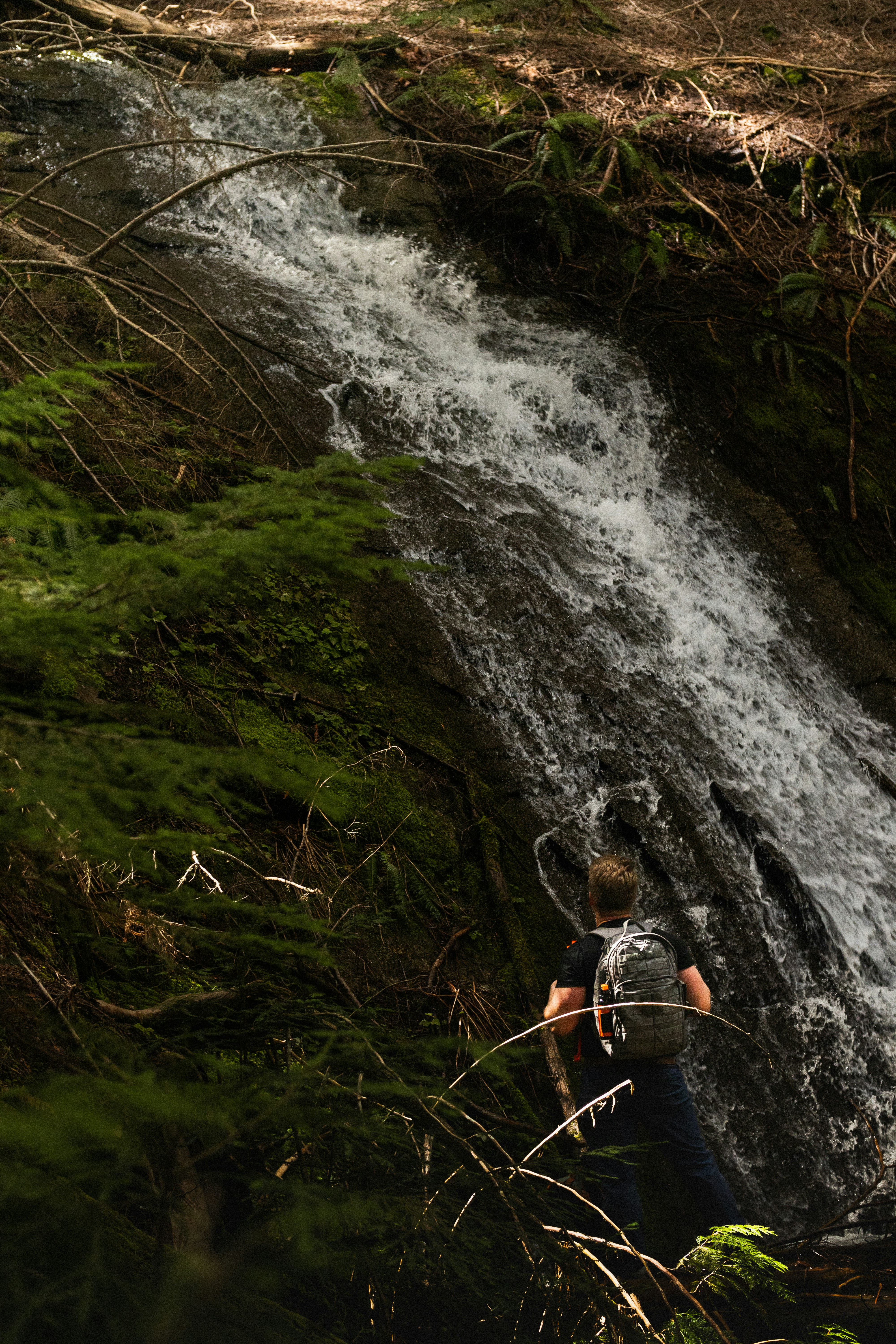 a man standing in front of a waterfall