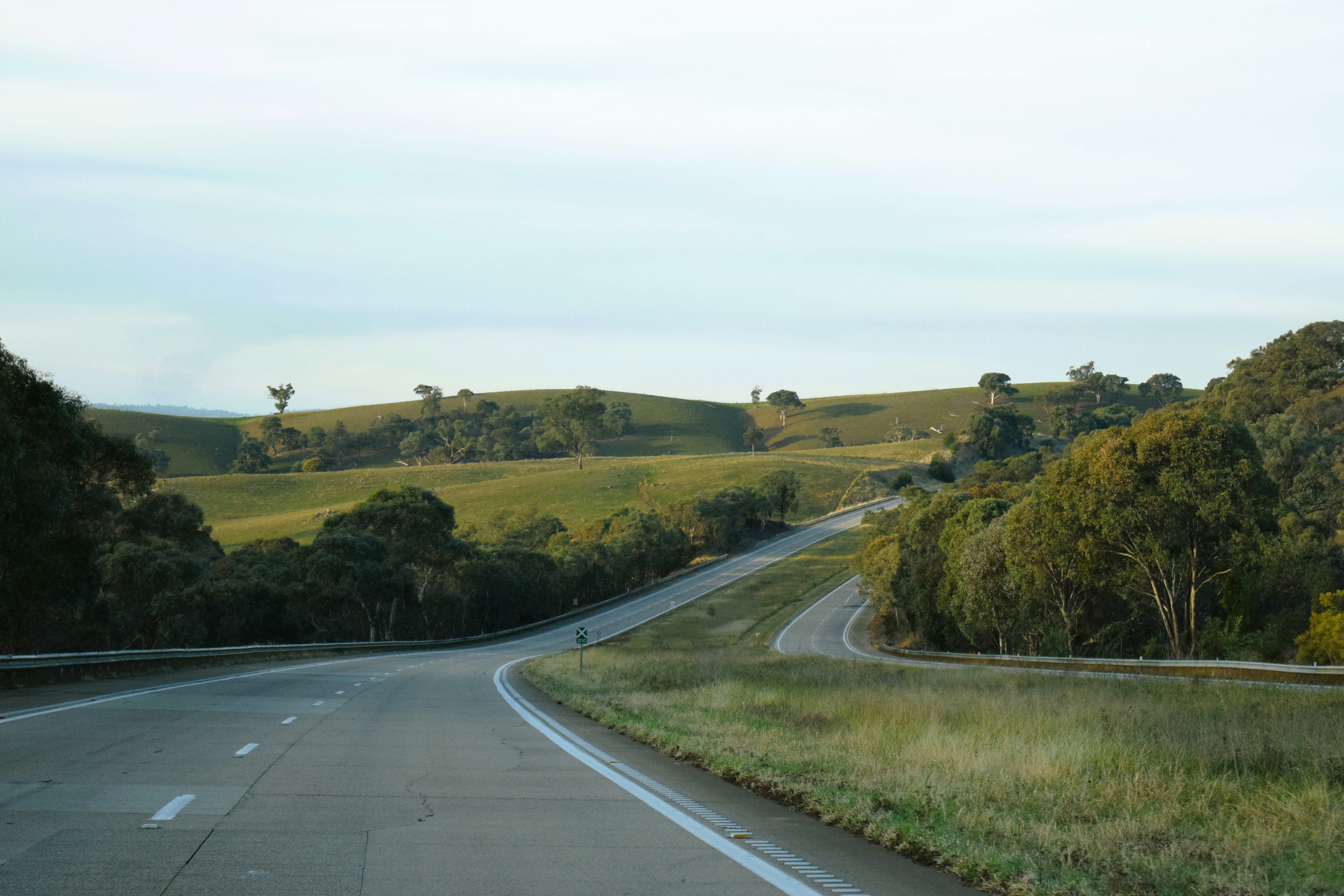 a curved road surrounded by lush green hills