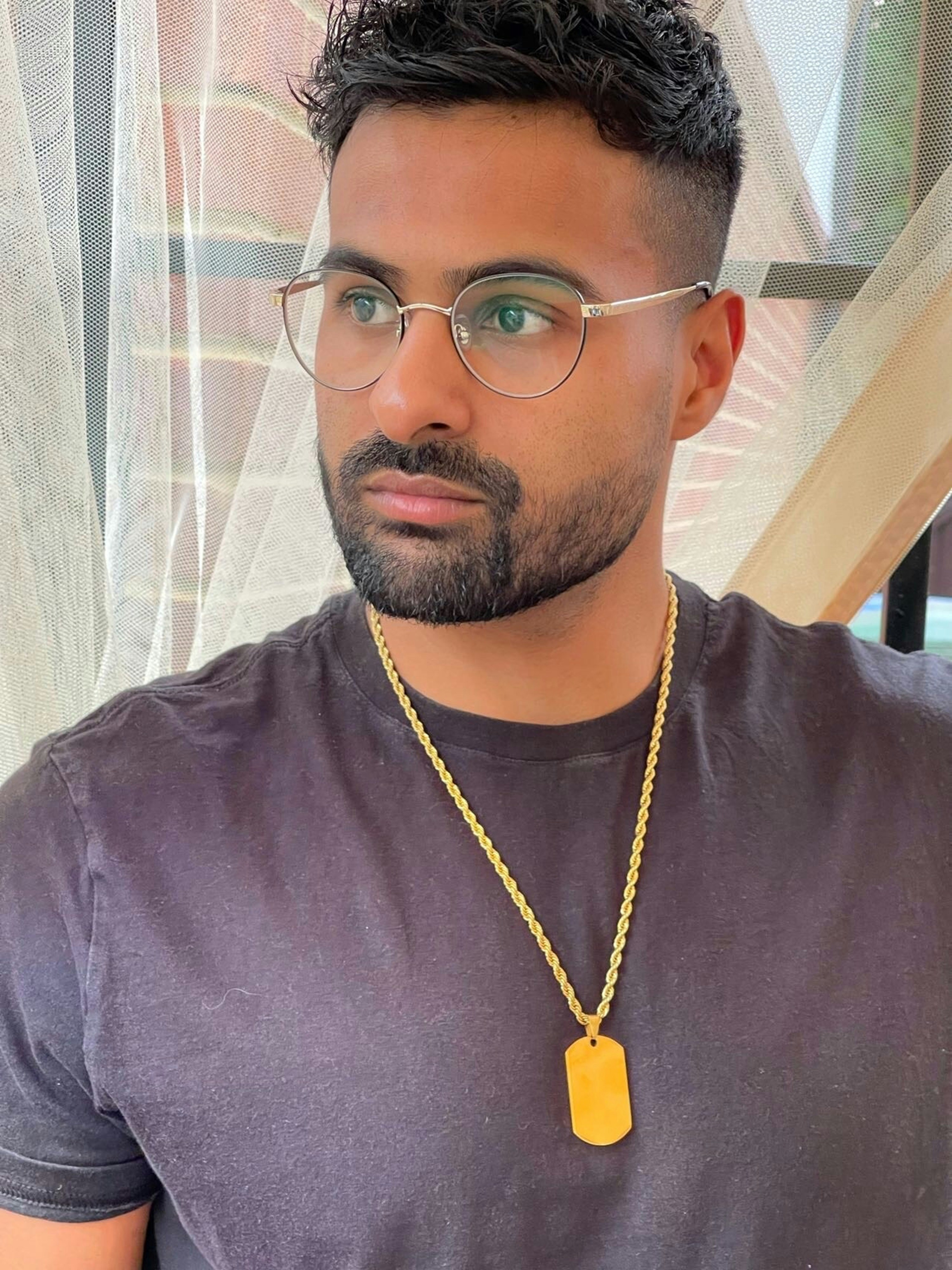 a man wearing glasses and a necklace with a tag on it