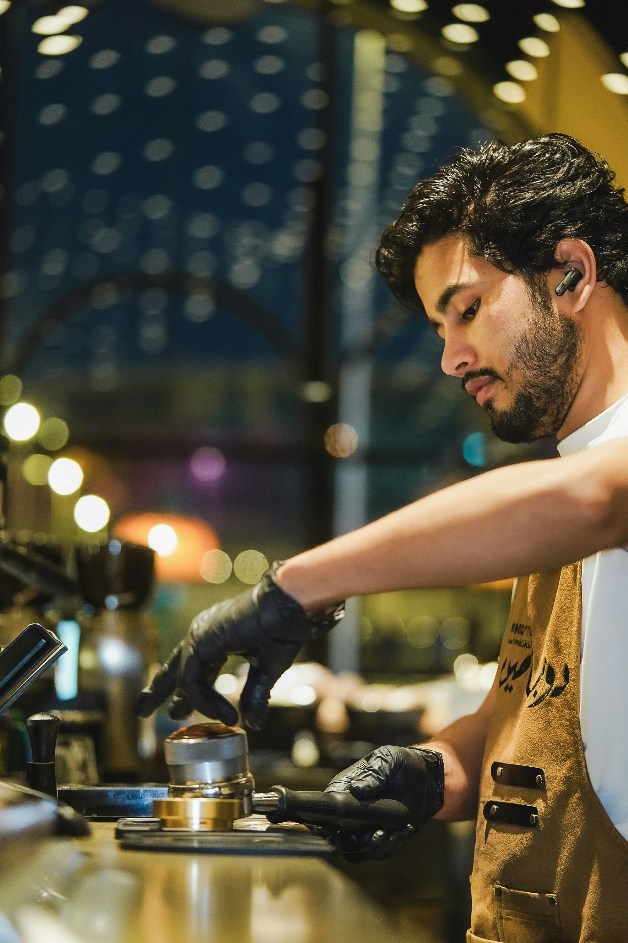 a man wearing a vest and gloves is working on a machine
