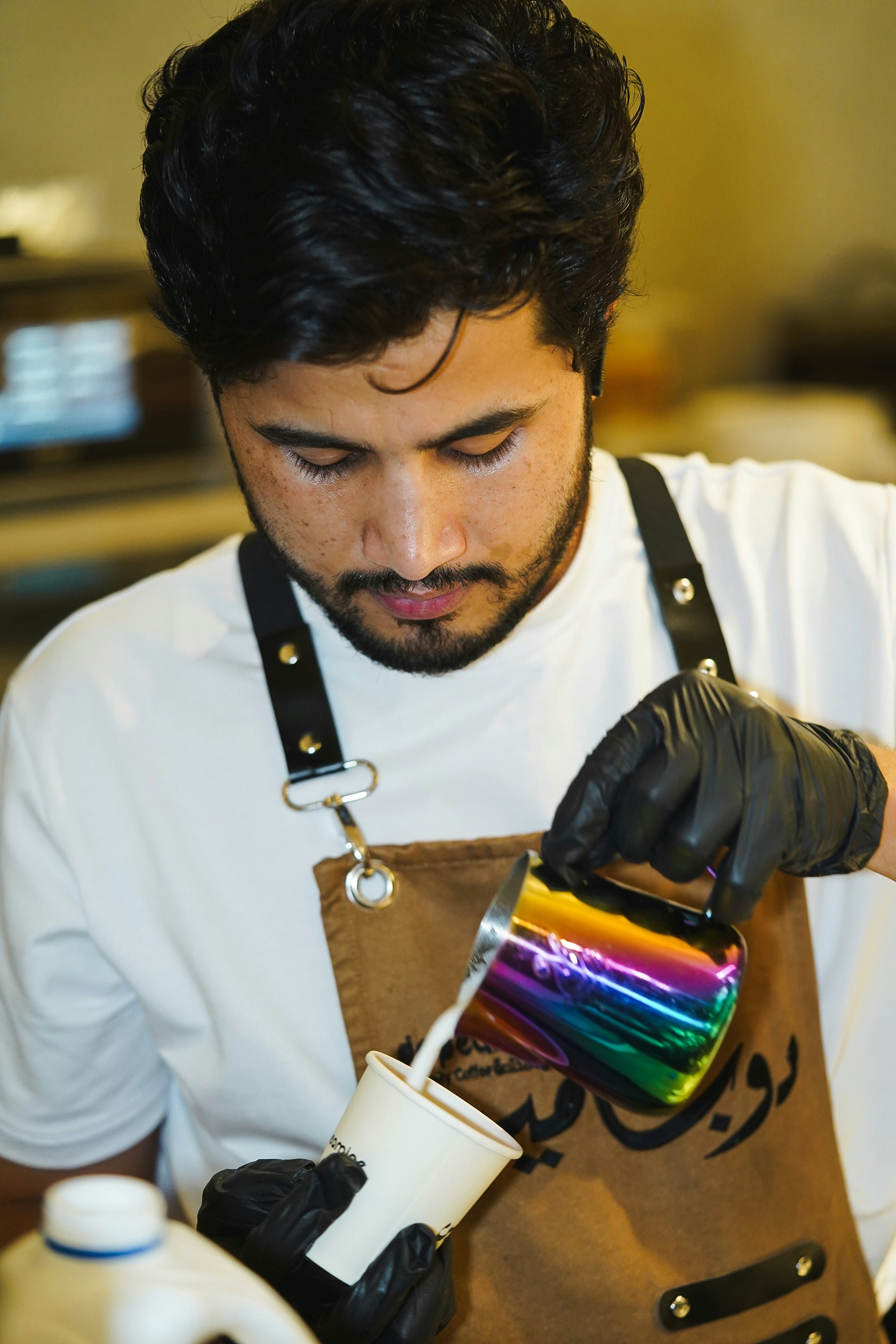 a man in a white shirt and black gloves holding a paintbrush