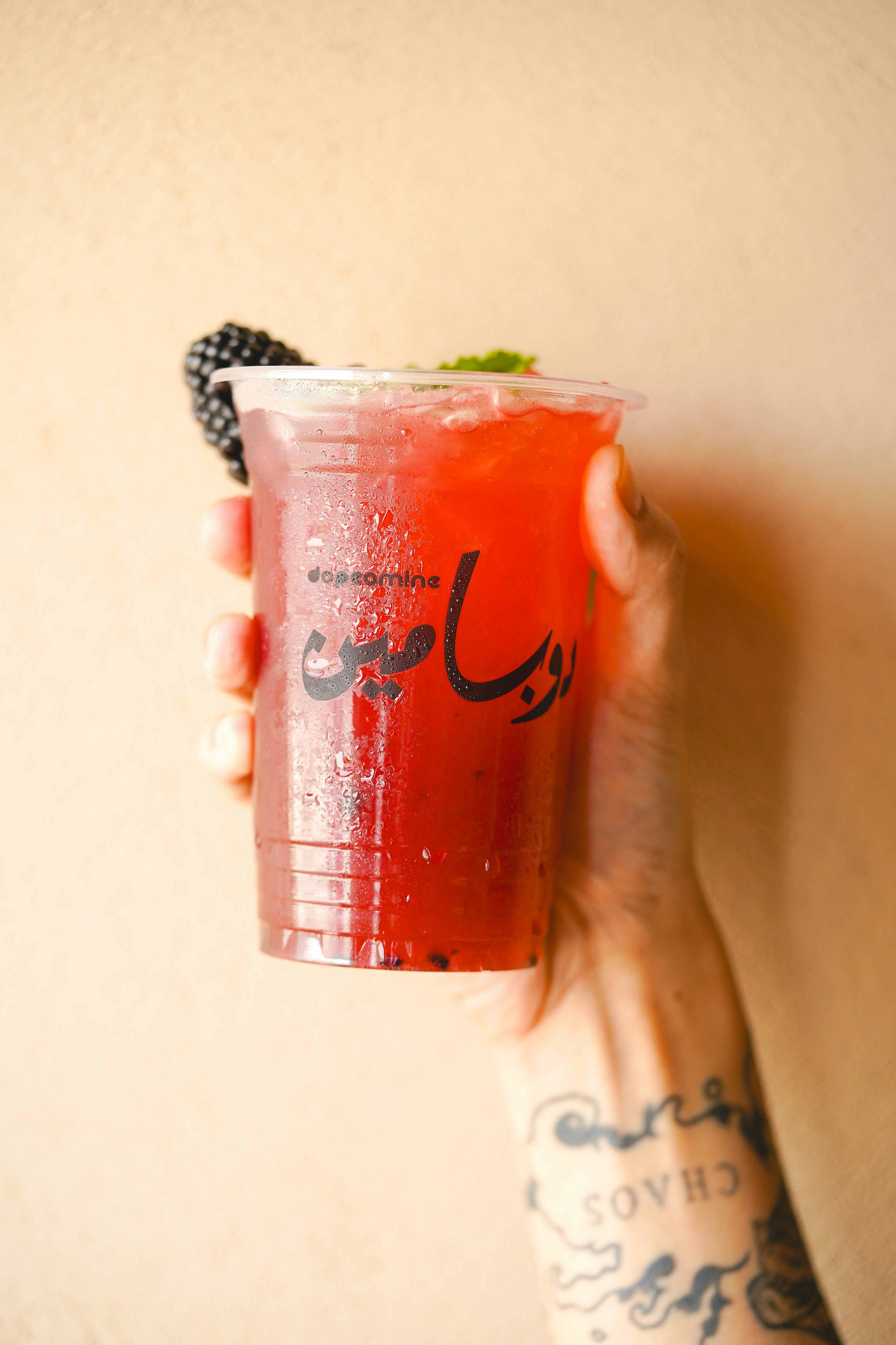 a person holding a drink in their hand