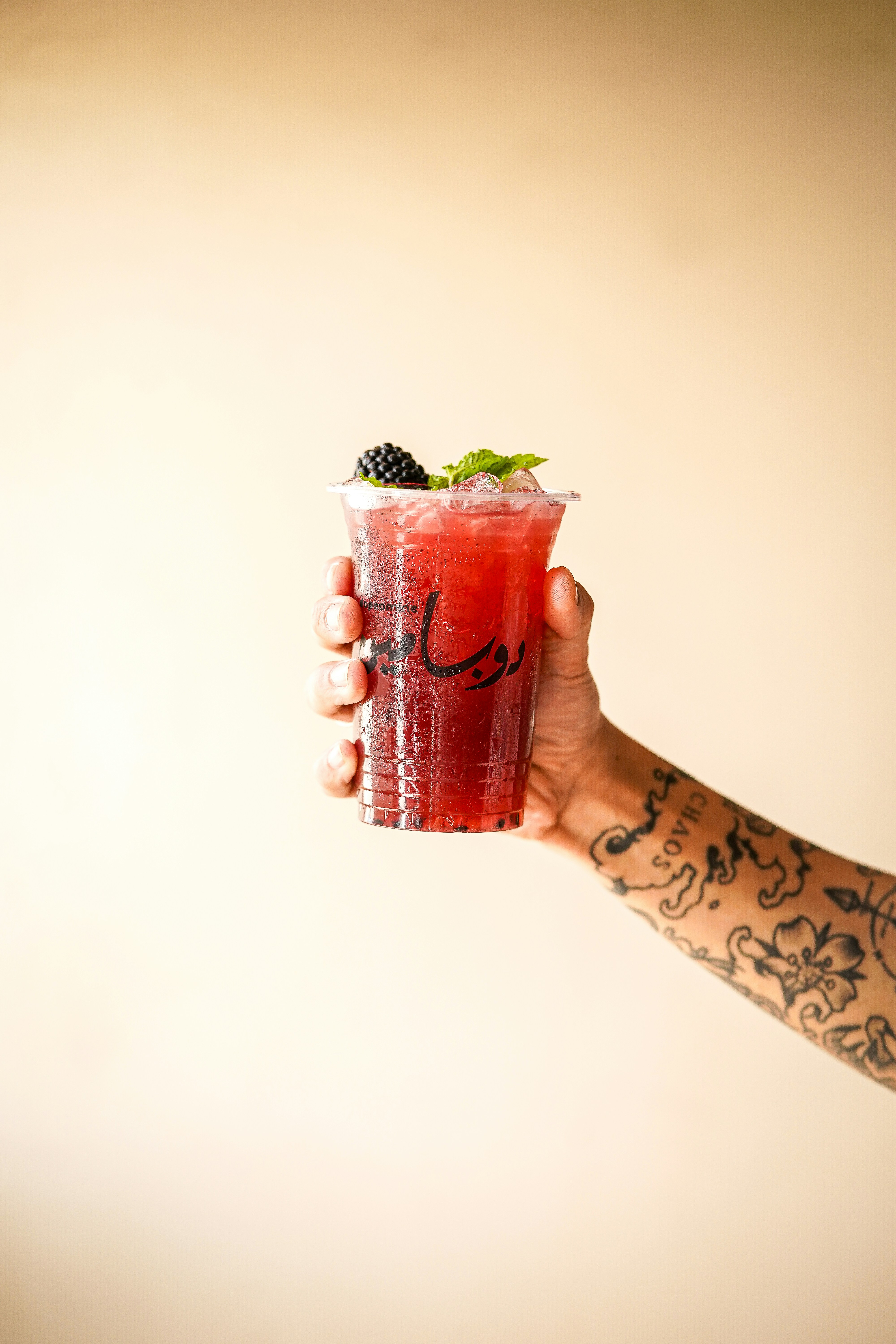 a person holding a drink in their hand