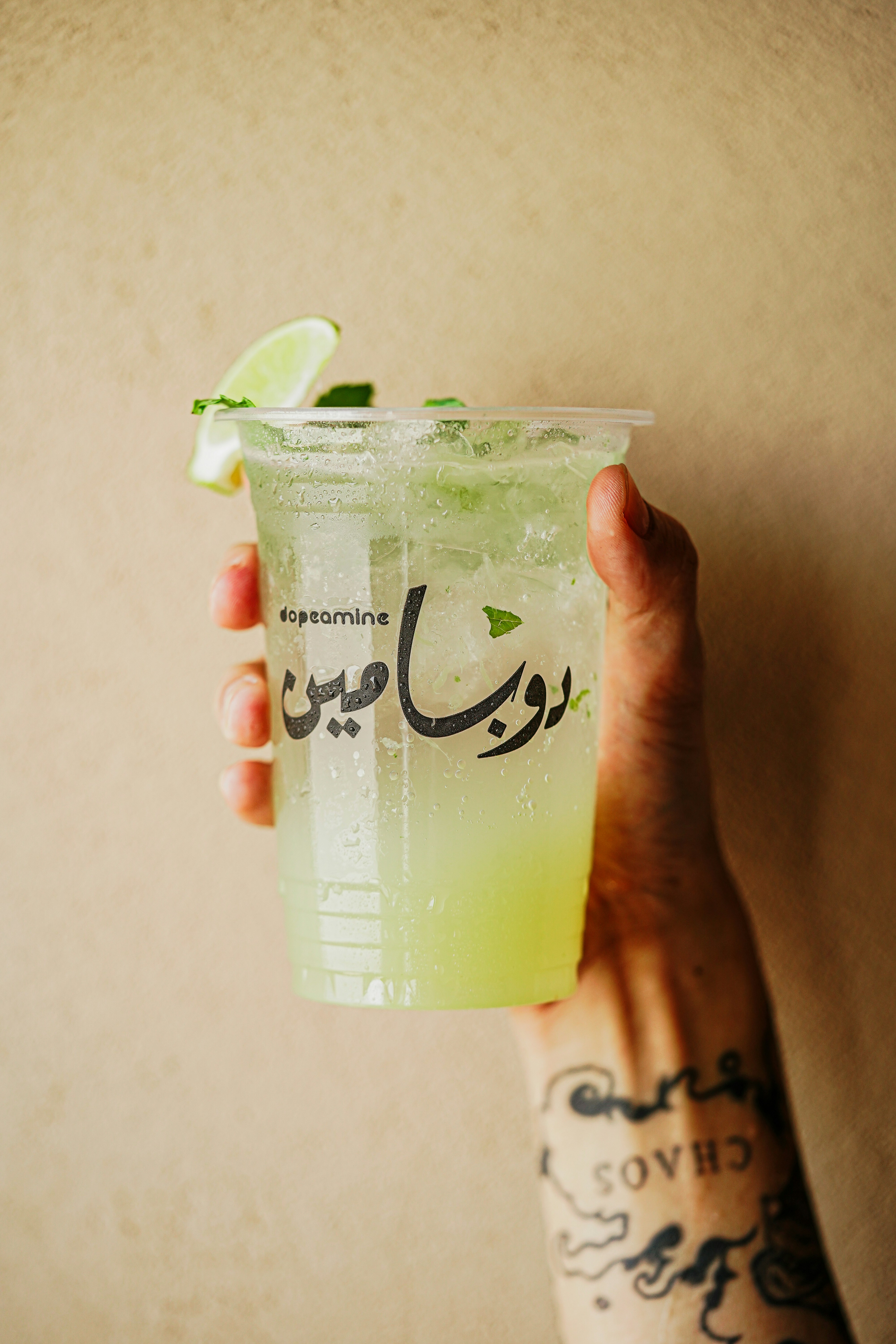 a person holding a cup with a lime in it