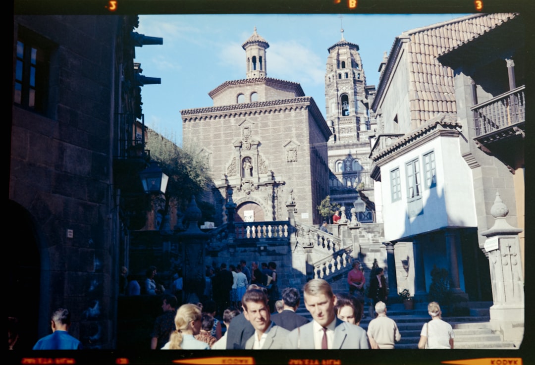 a group of people walking down a street next to tall buildings,