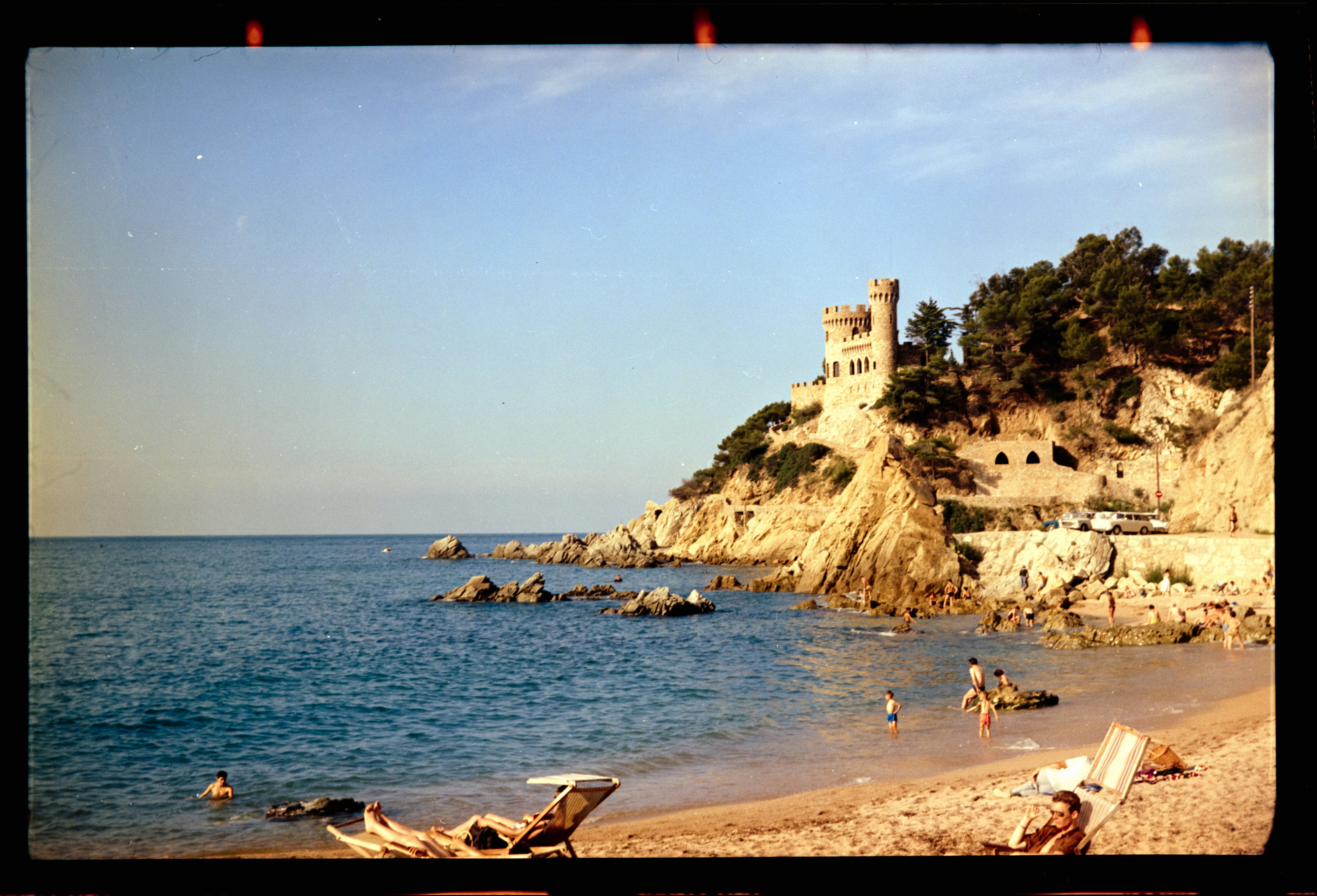 a picture of a beach with a castle in the background