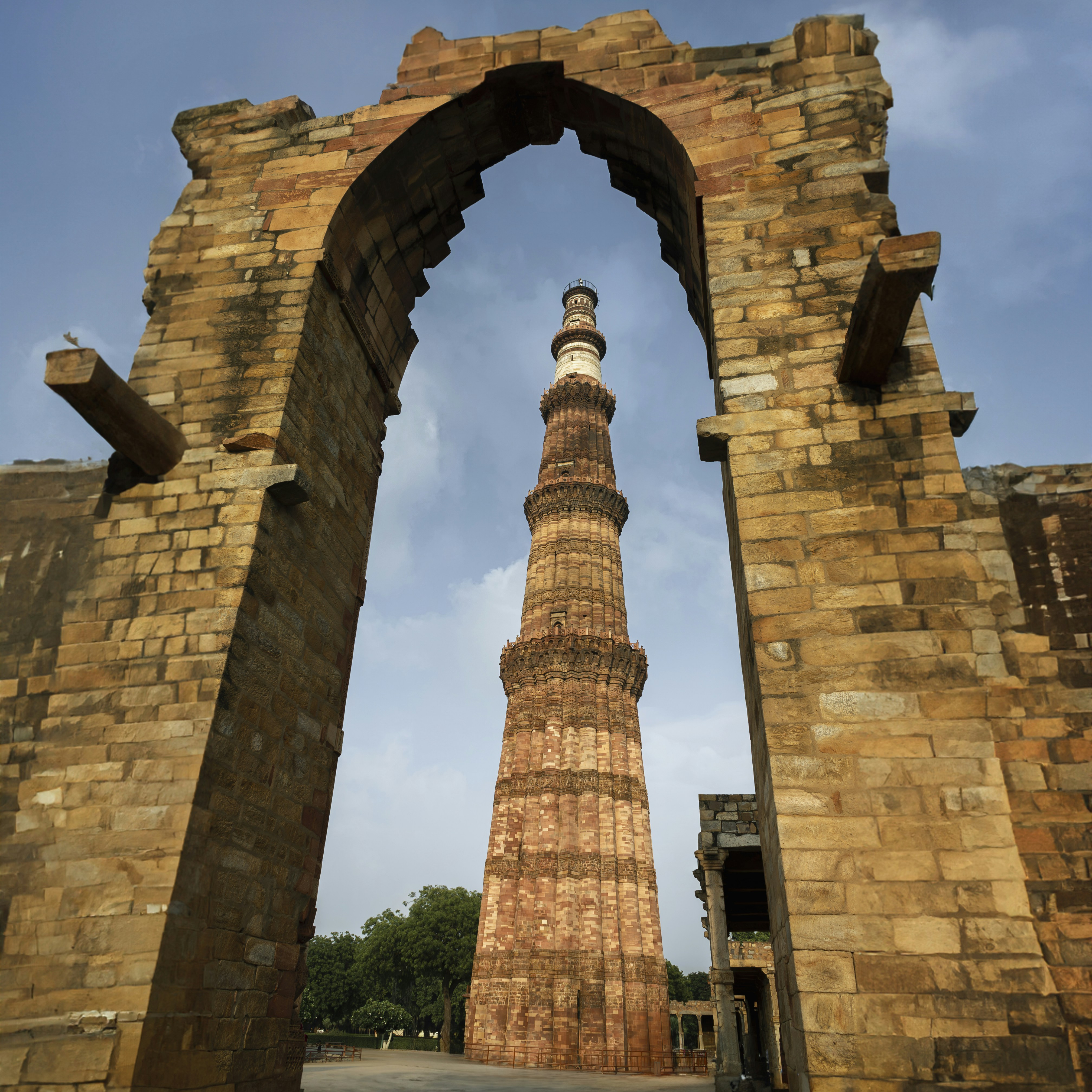 a tall brick structure with a clock tower in the background