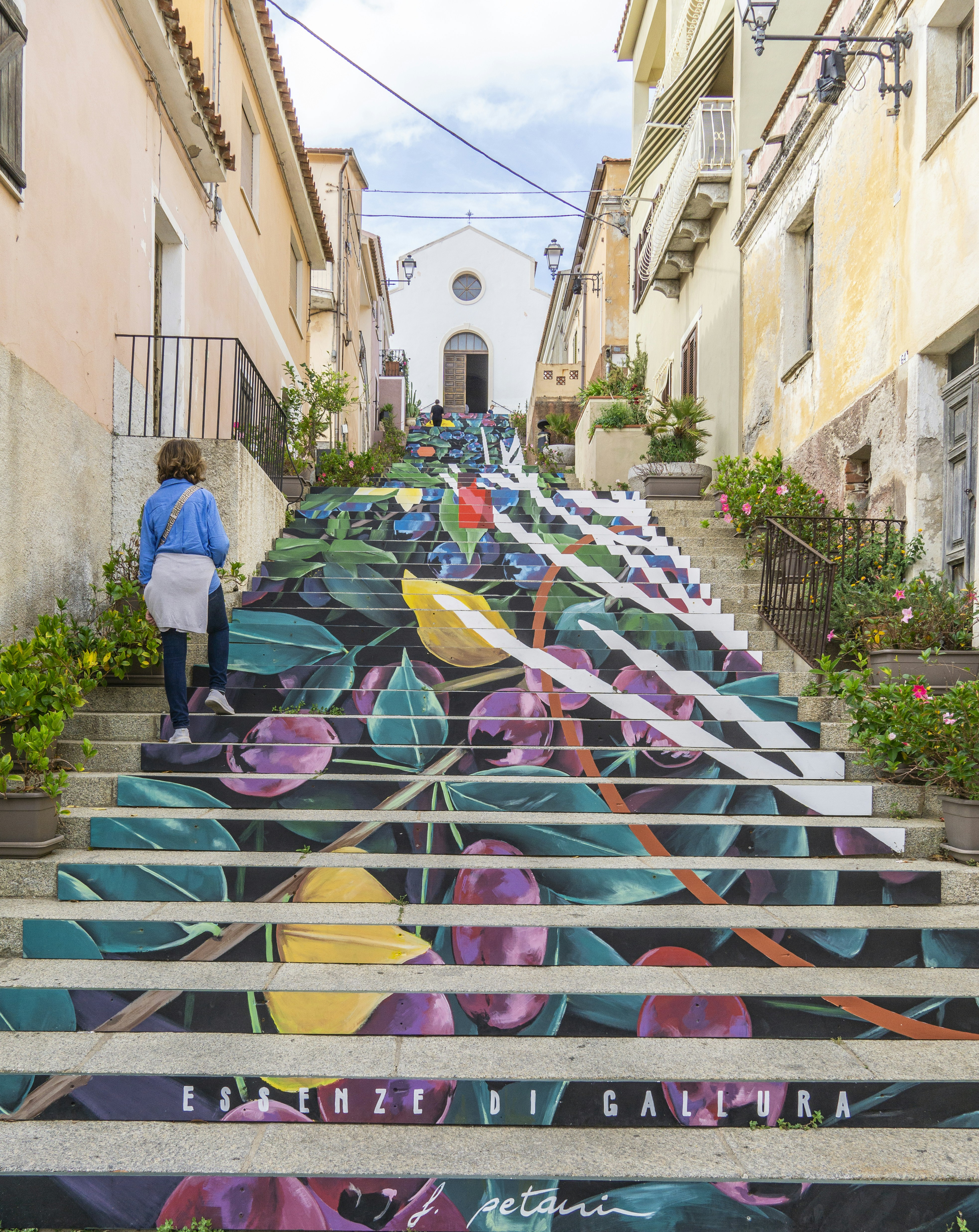 una donna che scende una rampa di scale dipinta di fiori