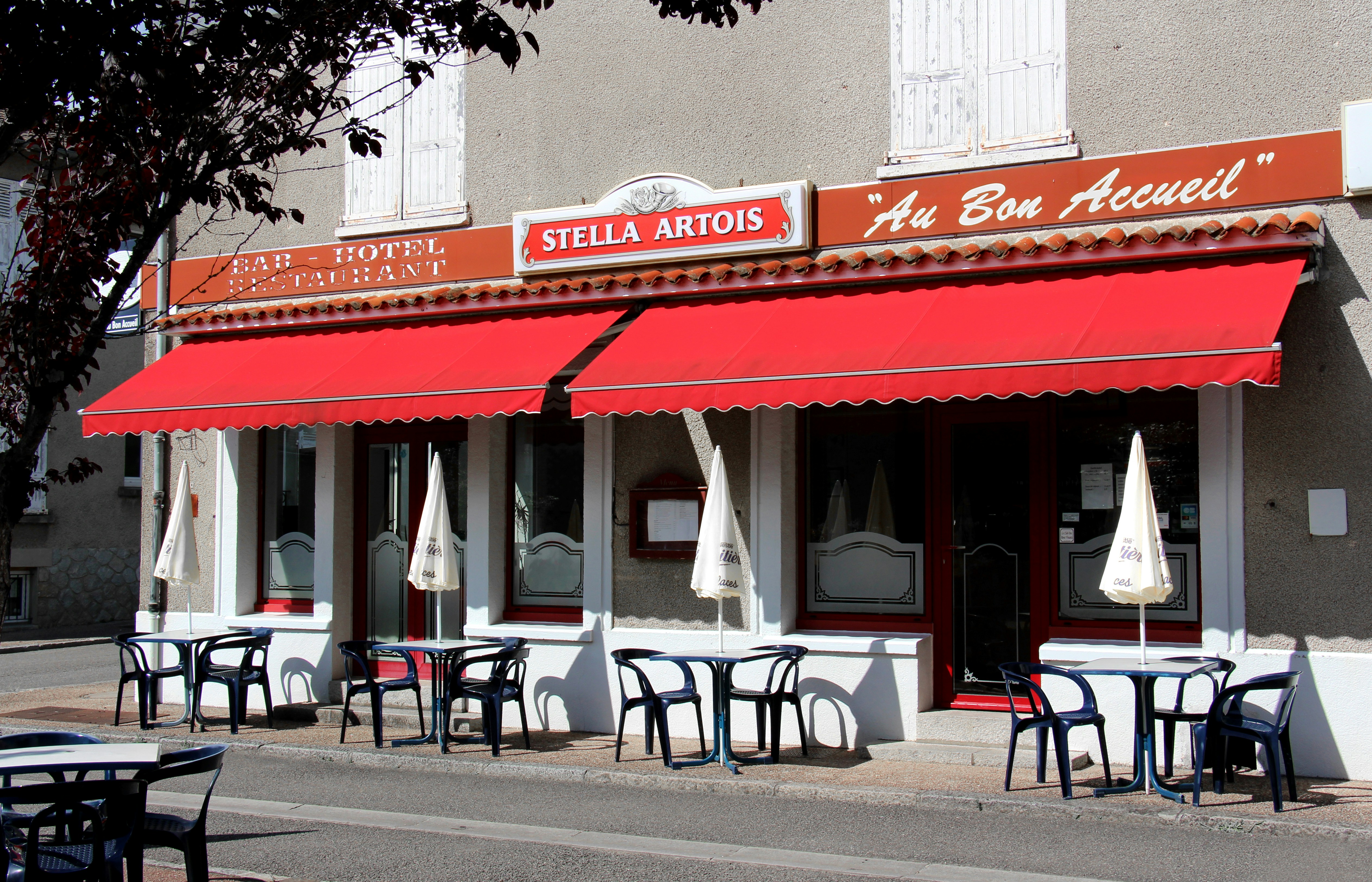 un ristorante con tende rosse e tavoli all'esterno