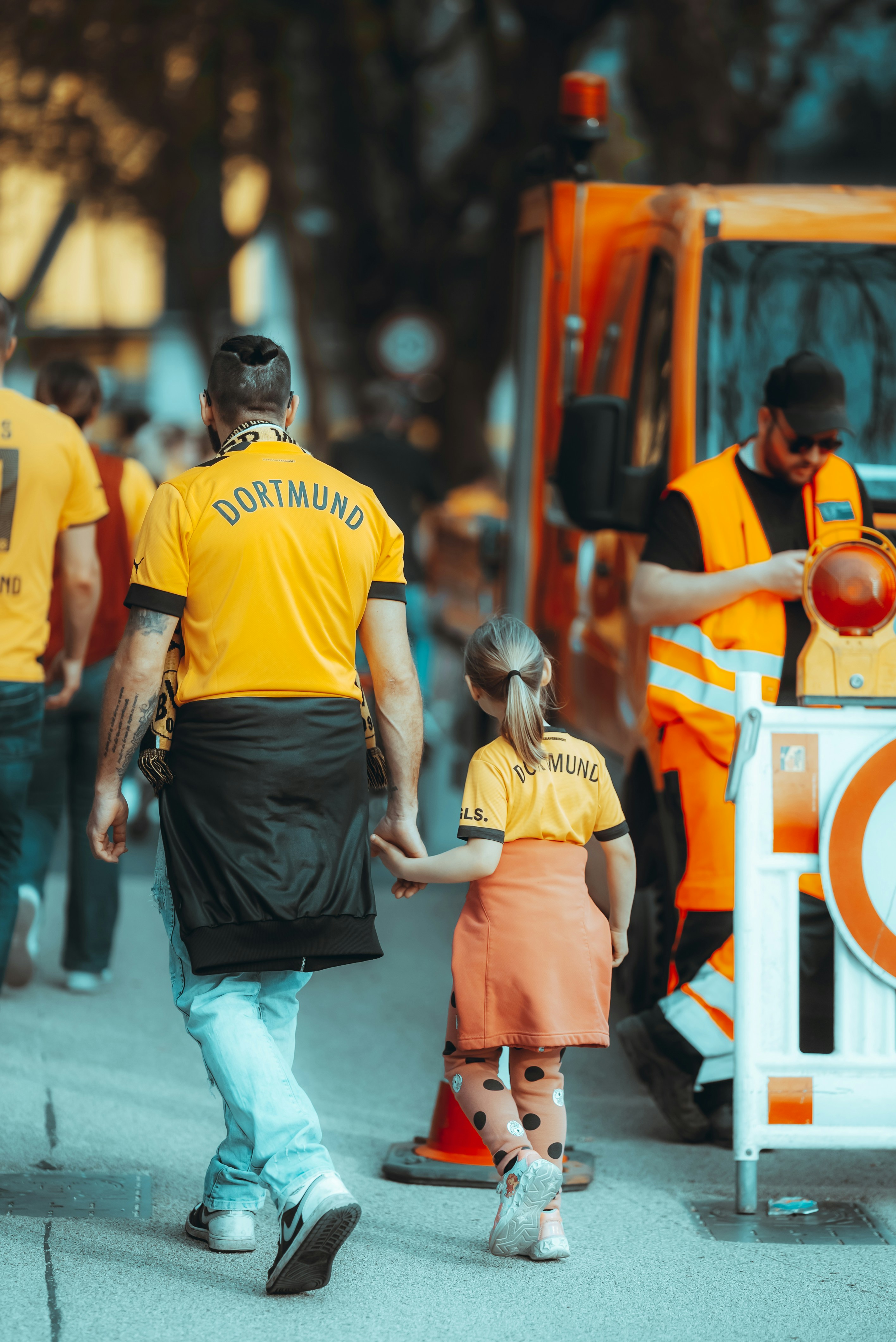 a man and a little girl walking down a street